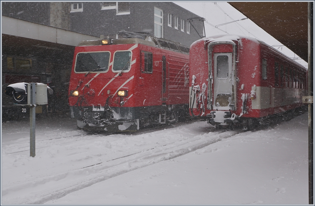 Schnee in Andermatt. Im Winter verkehren die Züge von Andermatt nach Disentis mit Komposition und HGe 4/4 II, auch wenn Umlaufbedingt, eine Komposition in Andermatt jeweils eine Stunde warten muss.
Auf dem Bild ist die HGe 4/4 107 zu sehen und ein Teil des angekommen Zuges aus Disentis. 
5. Jan. 2017