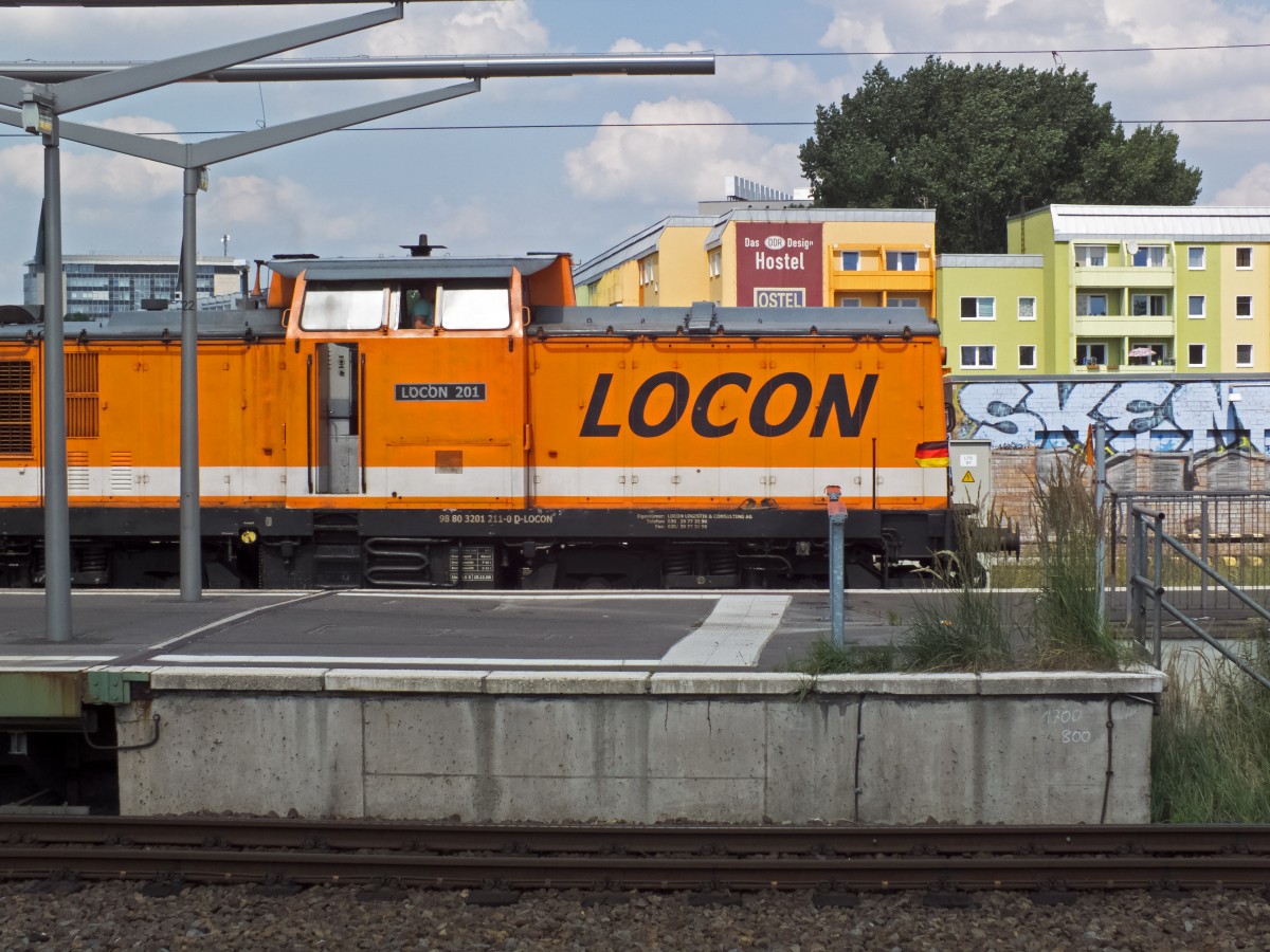 Schon wieder schwarz-rot-gold! Und dank Fahrtwind auch so schön erkennbar! Diesmal an der im Bauzugdienst eingesetzten LOCON-Lok 201 (201 211), direkt vor einem Werbebanner für ein DDR-Hostel, da fühlt sie sich sicherlich heimisch.