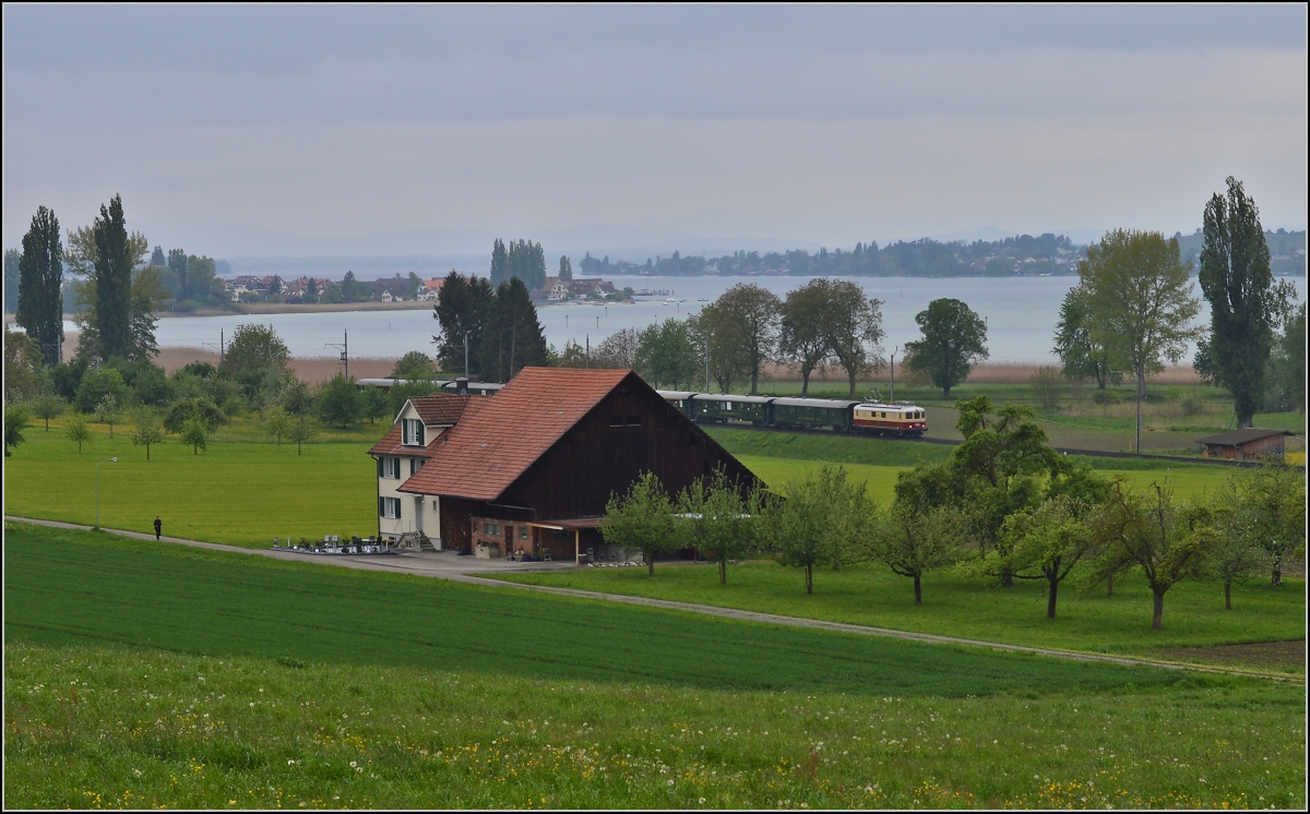 TEE am See. Die Re 4/4 I 10034 im Rot/Creme-Gewand und historischen SBB-Wagen am Untersee bei Triboltingen. Im Hintergrund Ermatingen und die Reichenau, der Hegau hat sich leider noch versteckt. Mai 2014.