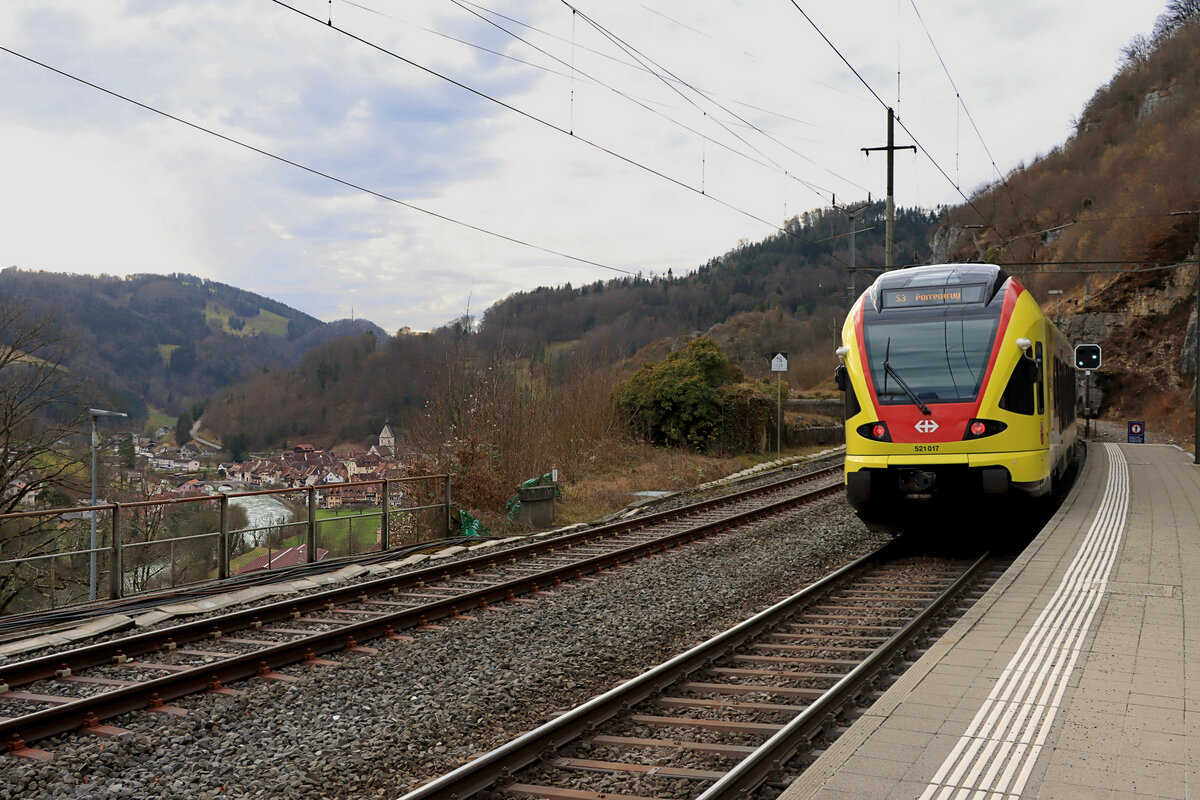 Vom Bahnhof St.Ursanne aus ist ein knapper Blick auf das Städtchen möglich. St.Ursanne ist die einzige schweizer Stadt direkt am Doubs, der sich auf abenteuerliche Weise dem Jura entlang von Frankreich her daherschlängelt, in St.Ursanne rechtsumkehrt macht und dann wieder in Frankreich nach Westen davonzieht. Aus St.Ursanne zieht auch der gelbe SBB-Flirt 521 017 davon, von Basel herkommend nach Porrentruy. 18.Februar 2022  
