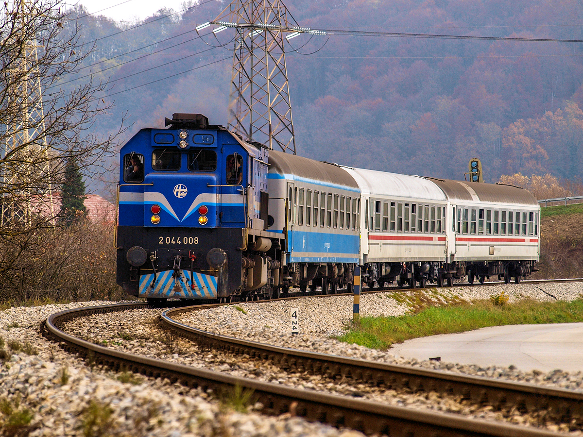 Vor drei Jahren war der Regionalzug 3011 von Varazdin nach Zagreb regelmäßig lokbespannt und verkehrte täglich. So präsentierte er sich uns auch am 24.10.2012. im gewohnten Erscheinungsbild, gezogen von der 2044 008 mit drei Abteilwagen am Haken. Mit dabei war einer der schon damals relativ seltenen Wagen in grau-blauer Lackierung. Kurz nach Mittag passiert er die letzte Kurve vor der Einfahrt in den Bahnhof von Zabok. Dort hat er eine Kreuzung mit dem aus Zagreb kommenden Gegenzug 3006 abzuwarten, dessen Endstation damals noch Kotoriba an der ungarischen Grenze war, ehe vor einem Jahr sein Umlauf bis nach Varazdin gekürzt wurde.