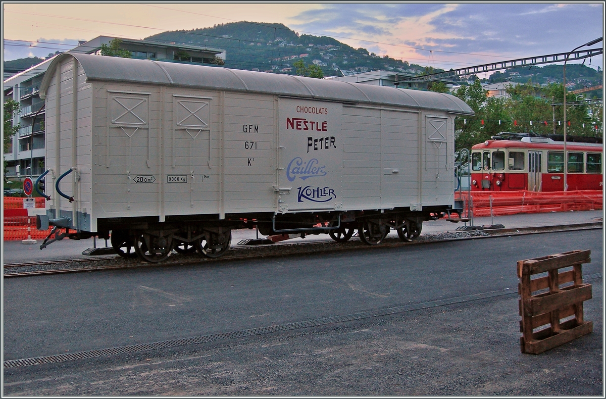 Vor Jahren nutzten die Industriebetriebe, die gleich nördlich des Bahnhofs Vevey lagen, ein durch eine Drehschiebe mit dem Bahnhof verbundenes Anschlussgleis. Nun sind die erwähnten Industiebetriebe durch ein Wohnquartier ersetzt worden und das ohnhin seit Jahren ungenutzte Anschlussgleis entgültig überflüssig. Doch interessanterweise hat man das Normalspurgleis aus dem Aspalt herausgearbeitet, ein kleines Stück mit einem Meterspurgleis versehen und nun einen GFM K3 Güterwagen zur Erinnerung hingestellt. Nestlé sei Dank. 27. Mai 2016