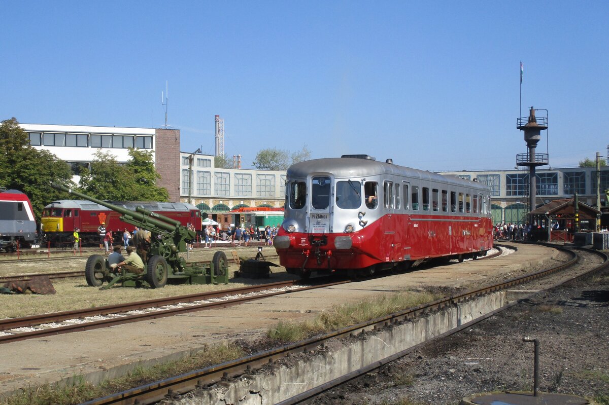 Während der Lokparade am 9 September 2018 ins Ungarischen Eisenbahnmuseumpark in Budapest passiert M260 001 ein FLaK, den von einer historische Gruppe vons Ungarischen Heer bereitgestellt wurde um am vorherigen Tag, 8 September, das Startschüss für ein Dampflok Grand Prix zu geben.