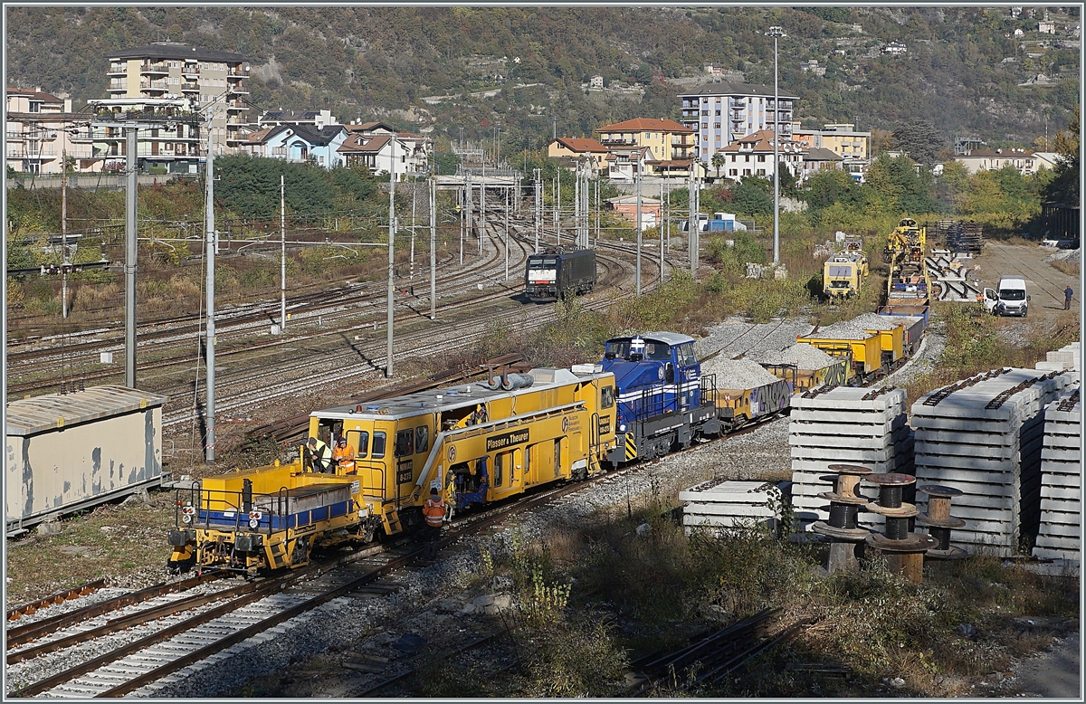 Während im Vordergrund der Gleisbauzug der Firma Valescchi Armamento Ferroviario S.R.L. vorbereitet wird, erreicht im Hintergrund die E 189 999-6  / ES 64 F4 099 (UIC 91 80 6189 999-6 D-DISPO Class 189VE) Domodossola, um auf der Güterzugsumfahrungsstrecke zum Bahnhof Domo II zu gelangen. 

28. Oktober 2021