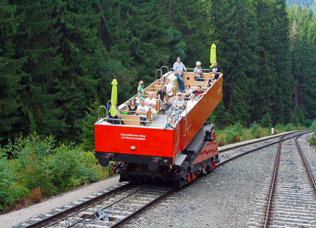 
Whrend wir mit dem Personenwagen (Wagen 1) Personenwagen der Standseilbahn der Oberweibacher Bergbahn uns am 24.08.2013 auf Talfahrt befinden, begegnet und in der Abt´sche Ausweiche (in der Mitte der Strecke) die Gterbhne (Betrieblich als Wagen 2 bezeichnet) mit dem darauf aufgesetzten Cabrio-Aufsatzwagen (Betrieblich als Wagen 3 bezeichnet).

Die einzigartige Besonderheit dieser Standseilbahn ist, dass sie fr den Transport von Eisenbahnwagen gebaut wurde. Die “Gterbhne” ist zum Transport normalspuriger Eisenbahnwagen bis 27 t Gesamtgewicht ausgelegt. Sie wurde gebaut fr den Gterverkehr, um die Hochebene um Oberweibach an das deutsche Eisenbahn-Netz anzuschlieen. Statt Gterwagen, ist heute in der Regel ein ehemaliger Triebwagen-Beiwagen oder das  Cabrio , ein offener Wagen, auf der Gterbhne aufgesetzt. Es ermglicht je nach Wetterlage nun den Wechsel der aufgesetzten Wagen zum Personentransport. 

Da das Cabrio deutlich lnger als der geschlossenen Aufsetzwagen (ein ehemaliger Triebwagen-Beiwagen) ist, ragt es weit ber die Gterbhne hinaus und man hat dadurch noch viel schnere Ausblicke, da man noch hher ber dem Gleis steht.

TECHNISCHE DATEN des Cabrio-Aufsatzwagen:
Spurweite: 1.435 mm
Anzahl der Sitzpltze: 38 
Anzahl der Stehpltze: 65 
Personen-Gewicht: 8,2 t 
Eigengewicht: 10,22 t
Lnge des Wagens: 11,27 m ohne Puffer
Lnge ber Puffer:  12,70 m  
Achsstand:  6,80 m   
Breite des Wagens: 2,83 m ohne Treppen/Notausstiege
Seitenwandhhe: 1,00 m 
