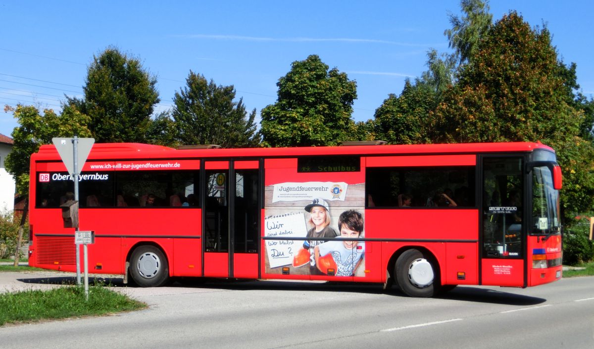 Wie mehrere Busse seiner Flotte hat Hinmüller Reisen aus Oberflossing bei Polling diesen Setra S 315 UL im Design der RVO / DB Oberbayernbus gestaltet und mit einer Werbefolie der Jugendfeuerwehr versehen. Dieses Exemplar ist bei Setra im Jahr 2000 vom Band gelaufen und hat 55 Fahrgastsitzplätze (mit kippbarer Sitzbank am Mitteleinstieg; Setra-Überlandbestuhlung Modell Special-Class mit Sicherheitsgurten) plus 2 Reiseleitersitze. Vorne, rechts und hinten ist jeweils eine LAWO-Matrix eingebaut. Der Antriebsstrang besteht aus dem Reihensechszylinder Typ MB OM 447 hLA mit 184 kW (250 PS) und dem Sechsgang-Handschaltgetriebe ZF S 6-85.
Abgelichtet wurde der Bus am Mittag des 17. 9. 2015 an der Wendeschleife vor der Inn-Apotheke in Kraiburg/Inn, als er aus Waldkraiburg kommend auf der RBO-Linie 6224 Kurs 034 unterwegs war.