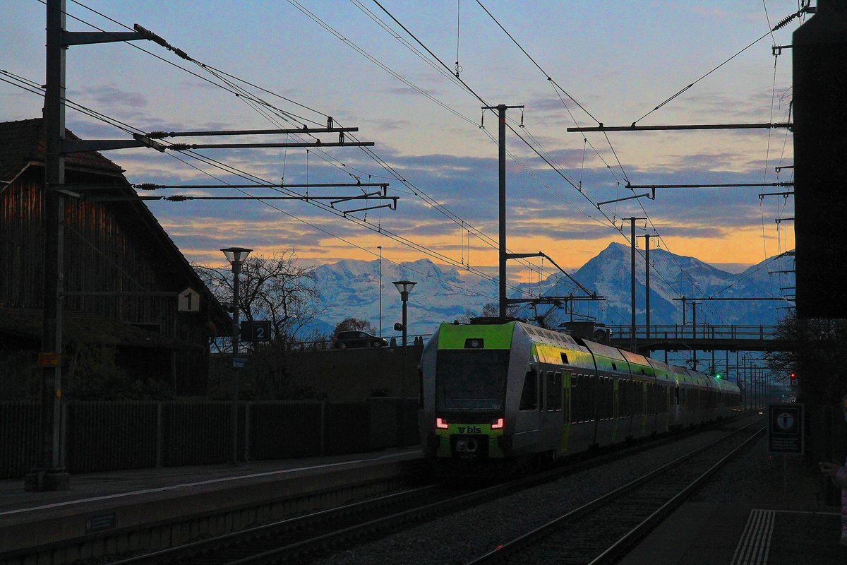 Zugsvielfalt bei Sonnenuntergang an der Bahnstrecke Bern-Thun: In der hereinbrechenden Dunkelheit ist der kurz zuvor nach Bern gefahrene BLS Lötschberger, jetzt mit Nr. 103 am Schluss, wieder unterwegs zurück; die hinteren beiden Einheiten nach Zweisimmen / die vordere Einheit nach Domodossola. Die L-förmigen Schlusslichter haben eine ganz eigene Wirkung. Bahnhof Wichtrach, 23.November 2020  