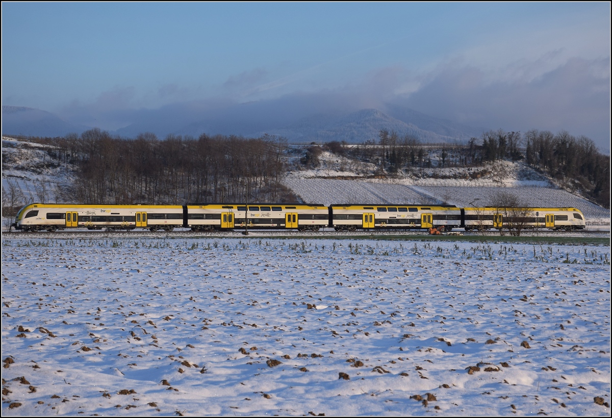 Zwischen Belchensystem und Blauendreieck. 

Ein Desiro HC von bwegt Richtung Basel bei Buggingen. Im Hintergrund befreit sich kurz vor Sonnenuntergang der Blauen aus seinen Nebeln. Februar 2021.