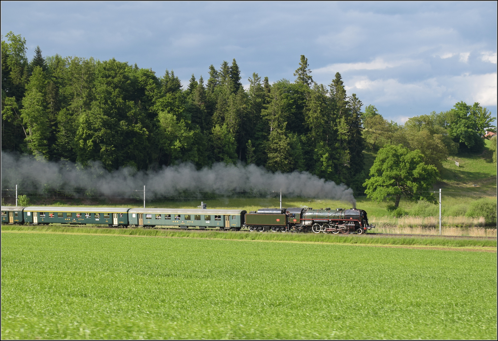 150 Jahre Emmentalbahn. 

141-R-1244 auf dem Rckweg von der grossen Emmentalrundfahrt anlsslich des Jubilums. Am Ortsausgang Menznau findet die Sonne ein Wolkenloch, freie Sicht auf die Strecke und die Strasse ist ohne Verkehr. Menznau Tuetisee, Mai 2025.