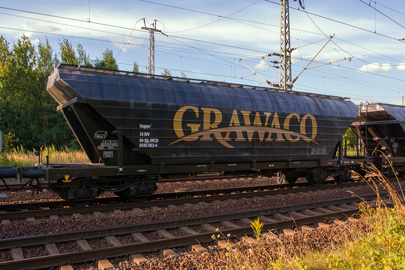 4-achsiger Drehgestell-Großraum-Getreidesilowagen 80 m³, 33 RIV 84 NL-WCB 9345 053-4 [P] der Gattung Uagpps der niederländischen Wagon Care B.V. / GRAWACO am 26 August 20213 im Zugverband bei der Durchfahrt in Pirna.