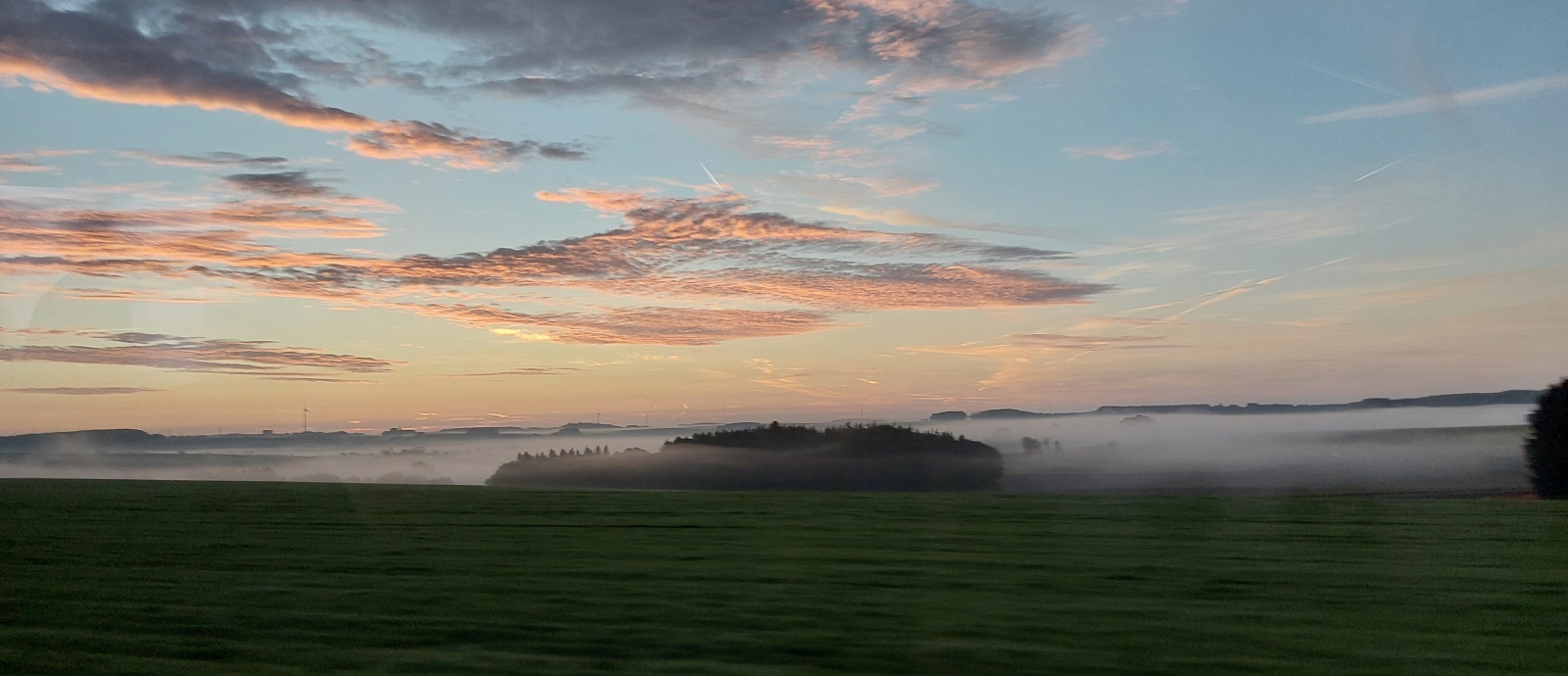 Busfahrt in den Sonnenaufgang. Zwischen Fetsch und Heisdorf h�ngen die Nebelschwaden �ber den Bergt�lern und die Wolken leuchten in voller Farbenpracht. 06.10.2023 (Jeanny)