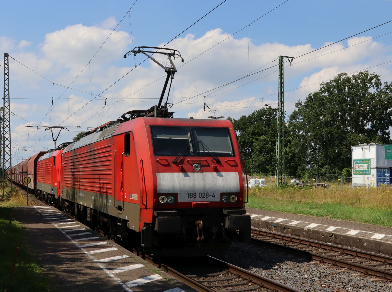DB Cargo Lokomotive 189 028-4 mit zusterloc durchfahrt Gleis 1 Bahnhof Empel-Rees 11-07-2024.

DB Cargo locomotief 189 028-4 met zusterloc doorkomst spoor 1 station Empel-Rees 11-07-2024.