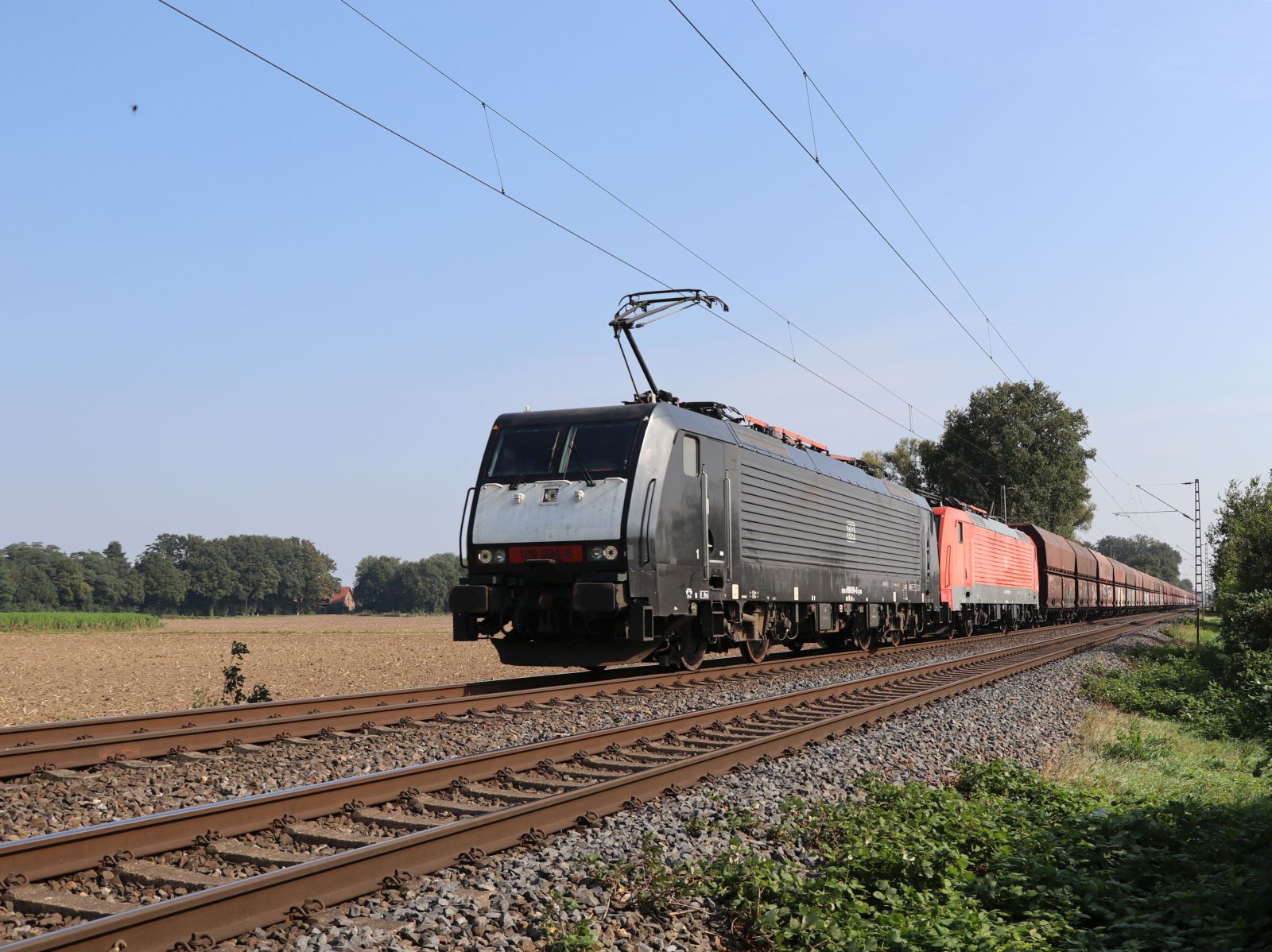 DB Cargo Lokomotive 189 094-6 und Schwestersterlokomotive bei Bahn�bdergang Wasserstrasse, Hamminkeln 19-09-2024.

DB Cargo locomotief 189 094-6 met zusterlocomotief bij overweg Wasserstrasse, Hamminkeln 19-09-2024.