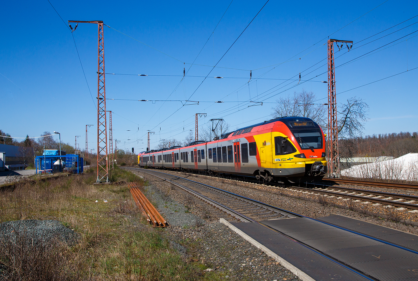 Der 5-teilige Stadler Flirt 429 043 / 429 543 der HLB (Hessischen Landesbahn) fährt am 04.04.2023, als RE 99  Main-Sieg-Express  (Frankfurt - Gießen - Siegen), durch Rudersdorf (Kreis Siegen) in Richtung Siegen.