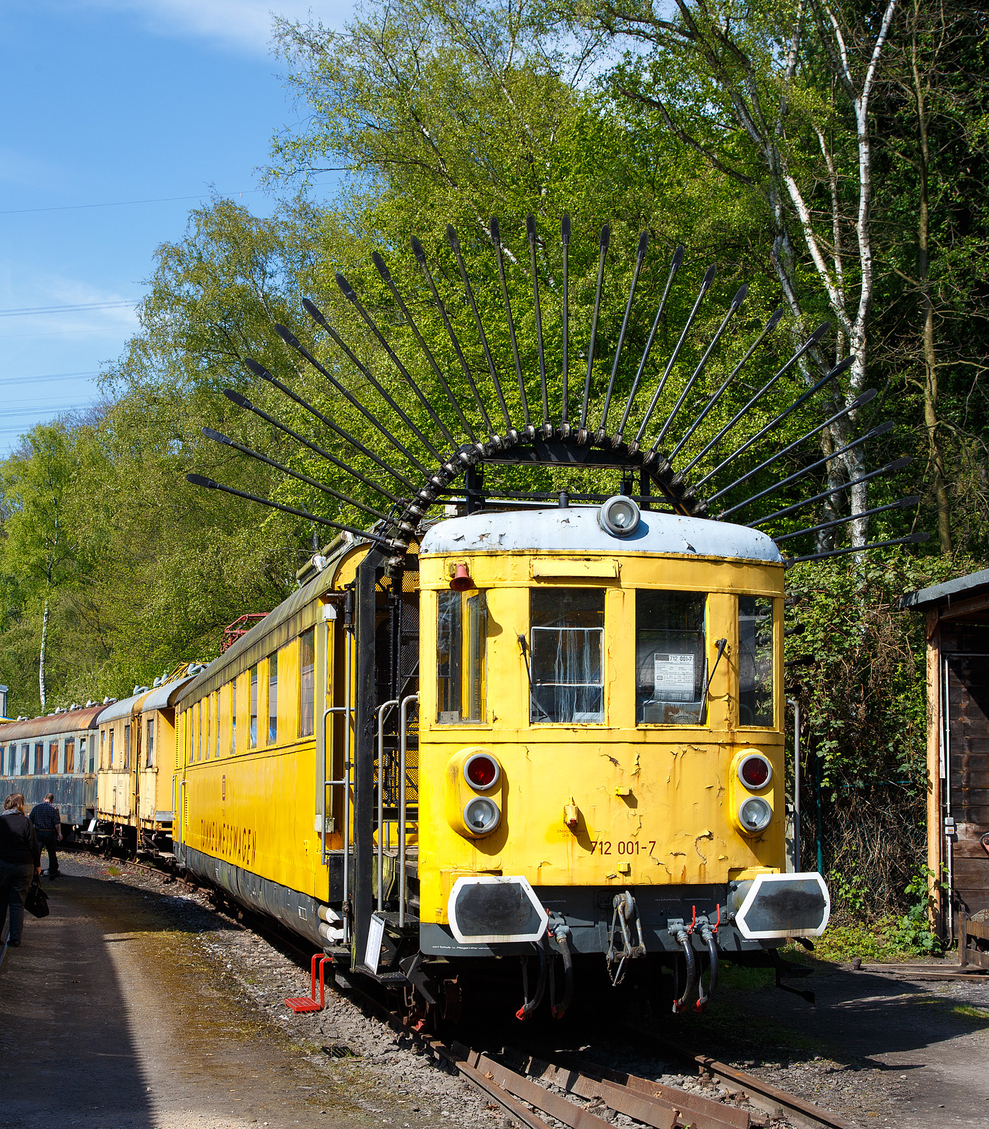 Der „Tunneligel“  712 001-7, ex DB Karlsruhe 6210, am 30.04.2017 im Eisenbahnmuseum Bochum-Dahlhausen.

Unter der Bezeichnung 712 001-7 setzte die Deutsche Bundesbahn von 1965 bis 1993 diesen Tunnelmesswagen ein, welcher wegen seines charakteristischen Erscheinungsbildes auch „Tunneligel“ genannt wird. Er verfügte neben mechanischen Messeinrichtungen zur Vermessung des Tunnel-Profils, auch über einen Messstromabnehmer, mit dem die Höhe der Oberleitung gemessen werden konnte. 

Recht selten wurden früher Bahndienstfahrzeuge als Neufahrzeuge ab Hersteller in Dienst gestellt. Meist wurden für derartige Zwecke Fahrzeuge verwendet, die im normalen Betrieb nicht mehr benötigt wurden. So entstand der hier gezeigte Tunnelmesswagen 712 001 im Jahr 1965 aus dem Eilzugtriebwagen VT 137 158 (ab 1957 – VT 38 002), welcher im Oktober 1960 ausgemustert worden war. Nach dem Umbau zum Messtriebwagen wurde er im September 1965, in roter Farbgebung, mit der Bezeichnung Karlsruhe 6210, wieder in Dienst gestellt. Seit 01.01.1968 trägt er dann, als Bahndienstfahrzeug, die EDV-gerechte Fahrzeugnummer 712 001-7. In den 1980er Jahren wurde er in das einheitliche gelb der Bahndienstfahrzeuge umlackiert.

Beim Umbau wurde ein Fahrzeugende völlig verändert. Der Fahrzeugstand 2 wurde vom Aufbau abgetrennt und auf das um 1.170 mm verlängerte Untergestell wieder aufgesetzt. In den entstandenen Zwischenraum wurden dann die Messfühler und die weiteren Messeinrichtungen  eingebaut. Das Fahrzeuginnere wurde völlig neu gestaltet. Die alten Fahrgasträume verschwanden, es wurden eine Werkstatt, Küche, Übernachtungsräume und der Messraum eingebaut. So konnte die Mannschaft während längere Messeinsätze, die in ganz Deutschland stattfanden, im Tunnelmesswagen an Bord bleiben. Die Tür und Fenstereinteilung blieb beim Umbau unverändert.

Tunnelprofile müssen in regelmäßigen Abständen überprüft werden. So wird überwacht, ob das Lichtraumprofil z.B. durch Bergsenkungen beeinträchtigt ist und dadurch Gefahren im Zugverkehr entstehen können. Dazu befährt der Tunnelmeßtriebwagen den zu messenden Tunnel mit ausgeklappten Messfühlern (wie hier zu sehen). Stoßen diese an die Tunnelwandung, so geben diese nach und neigen sich. Diese Änderung der Lage wird über Seilzüge in den Messraum übertragen und aufgezeichnet. Im Vergleich zu früheren Messungen kann nun festgestellt werden, ob sich das Tunnelprofil im Laufe der Zeit verändert hat. Dieser 712 001 wurde im Jahr 1994 durch den Profil-Messtriebwagen 712 002 (PROM), Baujahr 1993 von der Deutschen Plasser,  abgelöst.
Der Messwagen ist jedoch noch voll funktionstüchtig.

Das Maschinendrehgestell trägt auf einer Rahmenkonstruktion den Dieselmotor und den BBC-Generator für die elektrische Kraftübertragung. Zwei Gleichstrom-Fahrmotoren trieben die zwei Treibachsen an. Eine Langsamfahrschaltung ermöglicht konstante Geschwindigkeiten zwischen 2 und 6 km/h.

TECHNISCHE DATEN:
Gebaute Anzahl: 1
Baujahr: 1935 als VT 137 / 1965 Umbau zum Tunnelmesswagen
Hersteller (mechan. Teil) : MAN, Nürnberg
Hersteller (elektrischer Teil) : BBC, Mannheim
Spurweite: 1.435 mm (Normalspur)
Achsfolge: 2' Bo' 
Länge über Puffer:  21.880 mm
Dienstgewicht:  49,1 t
Höchstgeschwindigkeit:  100 km/h 
Antrieb: Diesel-elektrischer Antrieb 
Motor: Zwölfzylinder-Viertakt-Dieselmotor mit angebautem BBC-Generator
Installierte Leistung:  441 kW (600 PS)
Fahrmotoren: 2 Stück Gleichstrommotor mit je 180 kW Leistung
Treibraddurchmesser: 1.000 mm
Laufraddurchmesser: 900 mm


Noch ein paar Worte zu den DB VT 38 000–003, ex DR VT 137 156–159, da nur dieser in abgeänderter Form erhalten geblieben ist:
Die Triebwagen-Baureihe DR 137 156 bis 159 waren dieselelektrische Triebwagen nach dem Muster der DR 137 094 bis 223, die mit einem aufgeladenen Zweiwellen- Dieselmotor von MAN ausgerüstet waren. Durch die erhöhte Motorleistung konnten sie auf steigungsreichen Strecken eingesetzt werden. Die Fahrzeuge gelangten nach 1945 in den Bestand der Deutschen Bundesbahn und wurden als Baureihe VT 38.0 bezeichnet. Ihr Einsatz dauerte bis 1965..

Geschichte
Da die Maybach-Motorenbau GmbH ihre Motorenpalette durch Motoraufladung in der Leistung steigern konnte, entschloss sich auch MAN für seine Zweiwellenmotoren zu dieser Maßnahme. Die Deutsche Reichsbahn bestellte vier Fahrzeuge mit dieser Motorkonfiguration, um Vergleiche bezüglich der Leistungsfähigkeit und der Fahrdynamik zu erhalten. Besonderes Augenmerk wurde dabei auf den Steuerwagenbetrieb und beim Einsatz in schwierigen topografischen Verhältnissen gelegt. Die Fahrzeuge entsprachen dem Einheitsgrundriss und wiesen bedingt durch die geänderte Antriebsanlage einige Änderungen in der Maschinenanlage auf. Äußerlich waren sie als geänderte Einheitstriebwagen zu erkennen.

Die Fahrzeuge wurden überwiegend auf der Schwarzwaldbahn eingesetzt. Dabei haben die Triebwagen in den drei Jahren bis Kriegsbeginn Laufleistungen zwischen 140.000 und 200.000 Kilometer zurückgelegt. Alle Fahrzeuge überstanden den Zweiten Weltkrieg und verblieben nach Kriegsende in den Westzonen. Sie erhielten 1947 die neue Bezeichnung VT 38 000–003.

Nach Kriegsende waren die Triebwagen lange abgestellt und wurde 1949 nach gründlicher Aufarbeitung im Ausbesserungswerk Friedrichshafen wieder in Betrieb genommen. 1954 wurde für die drei noch verfügbaren Triebwagen der Motortausch mit dem Maybach GTO 6 verfügt. Vollzogen wurde er lediglich bei VT 38 002 und VT 38 003. Bei den Triebwagen mit getauschtem Motor blieb die Baureihenbezeichnung unverändert. Die VT 38 000 und VT 38 001 erhielten keinen neuen Motor, ersterer schied bereits 1952 aus, der VT 38 001 1955. Die verbliebenen Wagen taten Dienst bis 1960 und 1962. Während VT 38 003 nach der Ausmusterung zerlegt wurde, wurde VT 38 002 als Tunnelmesswagen 6210 Kar und ab 1968 712 001-7 weitergenutzt. In dieser Form diente er bis 1993 und wurde danach in den Bestand des Eisenbahnmuseums Bochum-Dahlhausen übernommen.