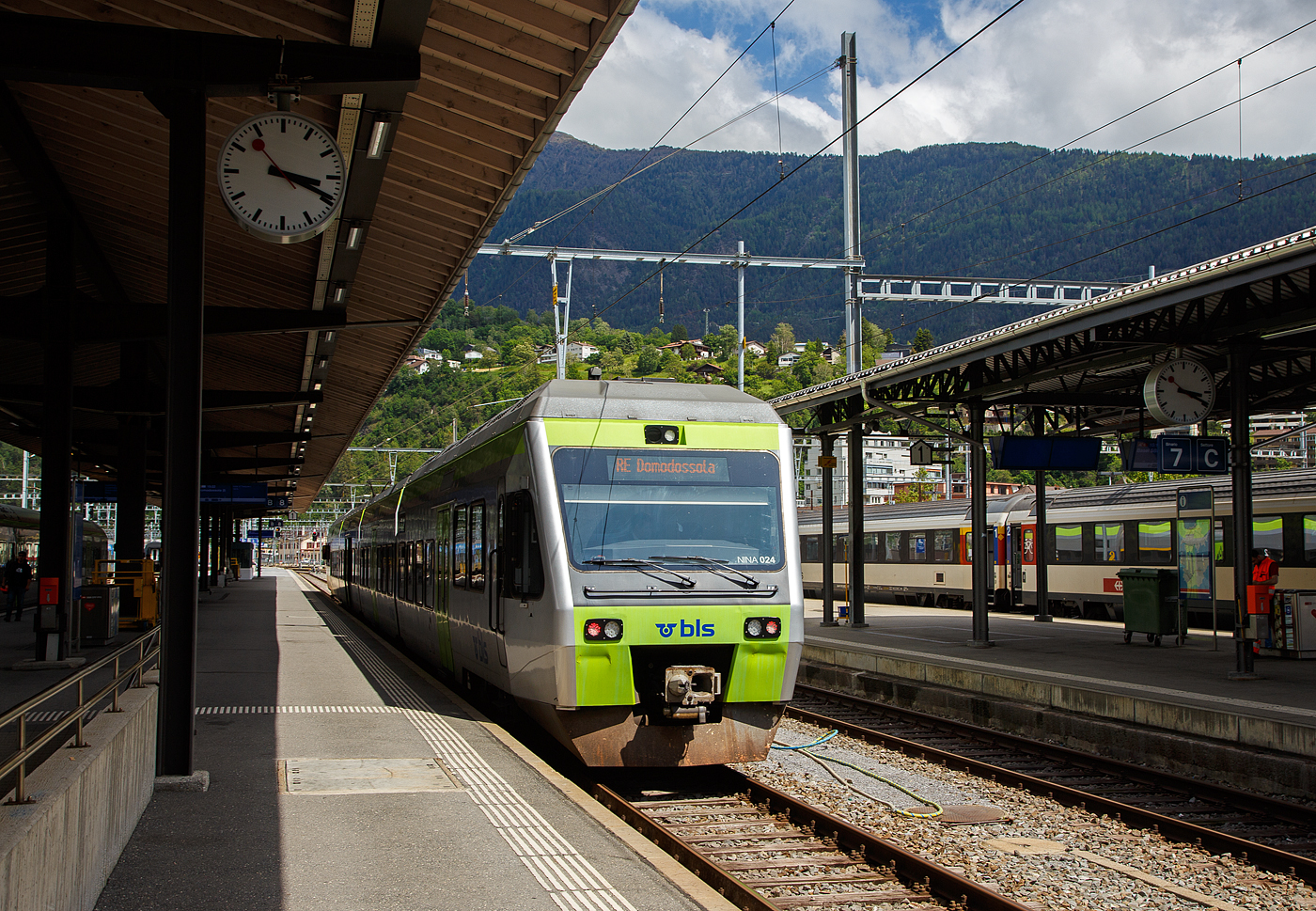 Der BLS NINA der 3. Serie RABe 525 024 (94 85 7525 024-6 CH-BLS) steht am 25.Mai 2023 im Bahnhof Brig, als RE nach Domodossola (Italien), zur Abfahrt bereit. 

Eigentlich sollten die BLS RABe 528 “MIKA” von Bern über die Lötschberg-Bergstrecke (Kandersteg) und Brig nach Domodossola fahren, aber diese haben noch keine Zulassung für Italien, die sie hinter dem SBB) Simplontunnel bis Domodossola brauchen. Und so wird der Zuglauf in Brig gebrochen und “NINA” fahren (min. bis zum Sommer) als Ersatz.