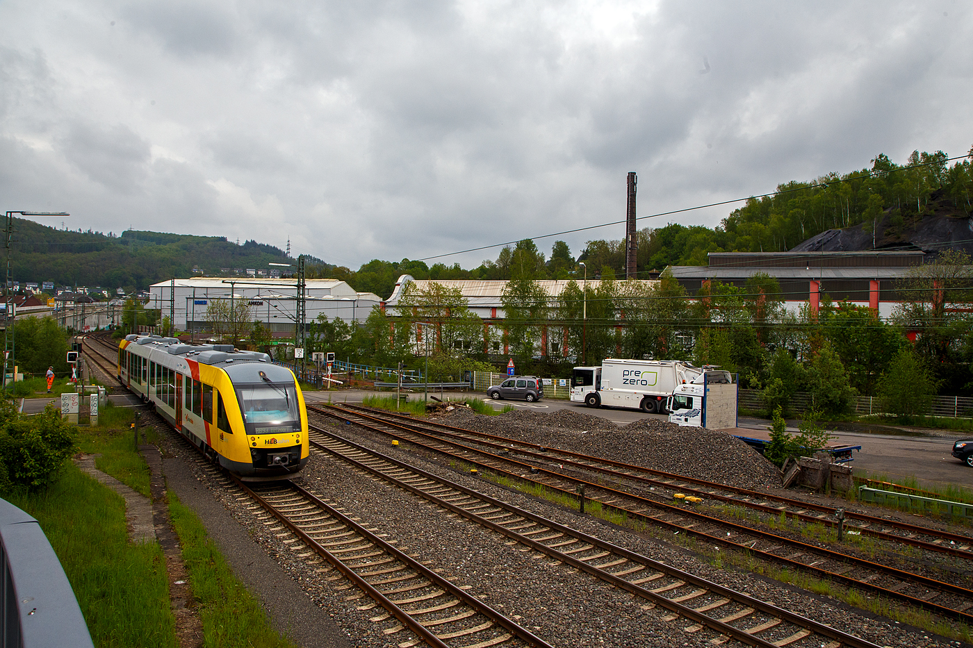 Der Dieseltriebzug VT 262 (95 80 0648 162-5 D-HEB / 95 80 0648 662-4 D-HEB) ein Alstom Coradia LINT 41 der HLB (Hessische Landesbahn), ex Vectus VT 262, erreicht am 11.05.2023, als RB 93 Rothaarbahn (Bad Berleburg - Kreuztal - Siegen Hbf - Betzdorf), bald den Bahnhof Niederschelden. 

Hier überquert er gerade den Bü 343 (km 112,183) und ist somit schon in Niederschelderhütte (PLP). Kurz dahinter verläuft die Sieg die auch Landesgrenze zwischen NRW (Nordrhein-Westfalen) und RLP (Rheinland-Pfalz) ist und die Orte Niederschelden (zu Siegen) und Niederschelderhütte (zu Mudersbach) trennt. So müsste der Bahnhof Niederschelden (heißt bei der DB so), müsste aber eigentlich Niederschelderhütte heißen, wo er liegt.

Im Hintergrund noch erhaltene Hallen der ehemaligen Charlottenhütte, sie war eine bedeutende Eisenhütte mit zwei koksbetriebenen Hochöfen.
