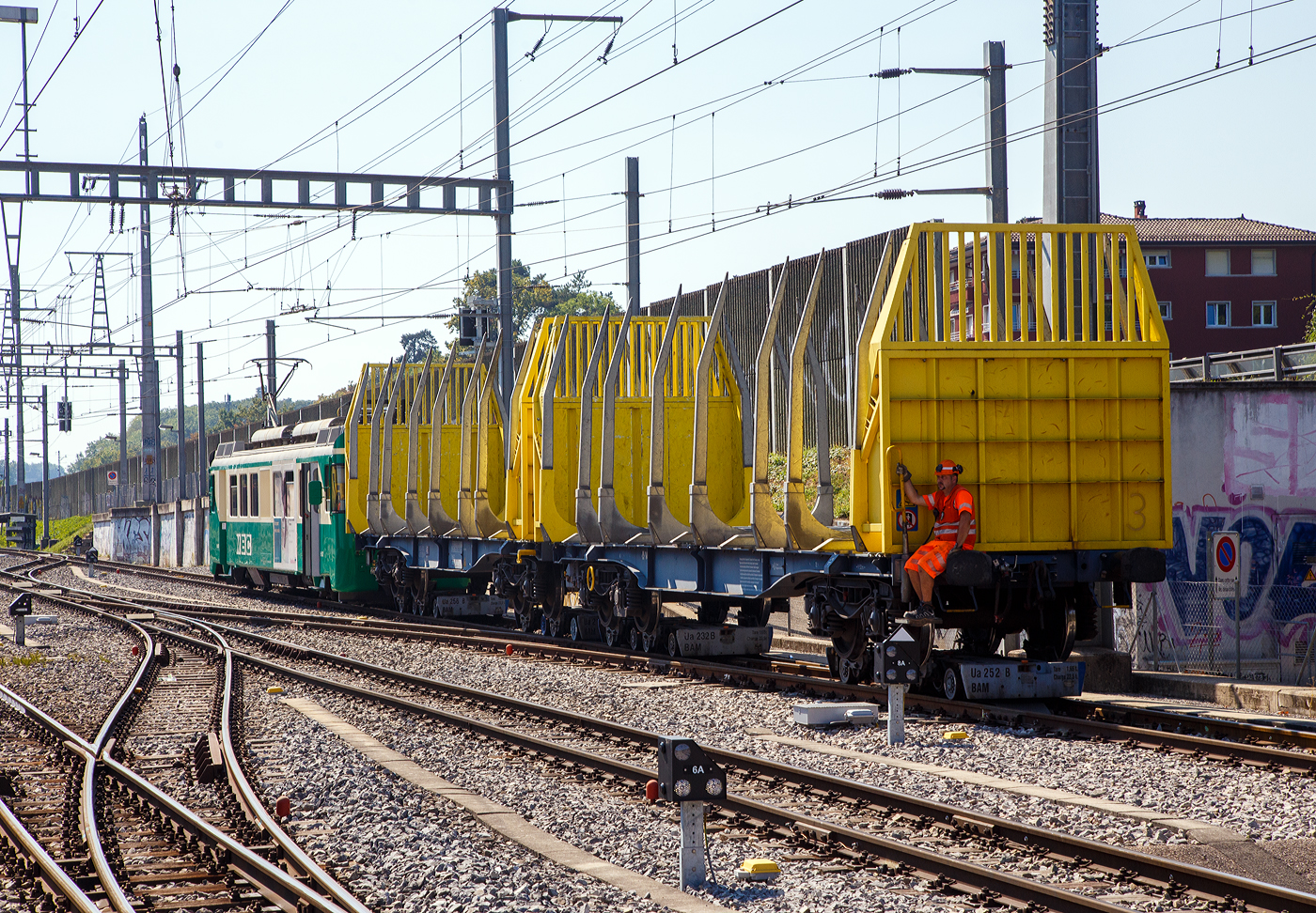 Der elektrische Schmalspur Güterzug-/Personentriebwagen MBC/BAM Be 4/4 12 rangiert, am 07 September 2023 beim Bahnhof Morges, den leeren auf schmalspurige Rollböcke vom Typ Vevey verladenen, 2 x vierachsiger Flachwagen in Sonderbauart (INNOFREIGHT Holz-Doppelwagen) 37 80 4657 028-9 D-VTG der Gattung Sggmrrs S240.