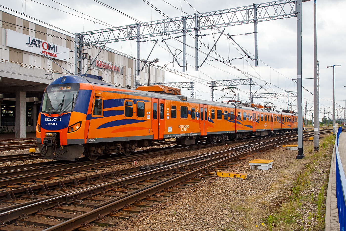 Der EN57AL-2111 (94 51 2 122 457-6 PL-PREG / 94 51 2 122 458-4 PL-PREG und 94 51 2 122 459-2 PL-PREG) ein modernisierter Triebzug vom Typ Pafawag 5B/6B der POLREGIO (Przewozy Regionalne Sp. z o.o.), ex EN57-1685, fährt am 25.06.2017 vom Hauptbahnhof Posen (Poznań Główny) in den Abstellbereich.

Der Triebzug wurde 1987 von PaFaWag in Wrocław unter der Fabriknummer 563 gebaut und als EN57-1685 an die PKP geliefert, seit 2008 bei der POLREGIO wurde er 2015 modernisiert und in EN57AL-2111 umbenannt.

Die Baureihe EN57 ist eine Baureihe dreiteiliger elektrischer Triebwagen ursprünglich der Polnischen Staatsbahnen (PKP). Seitdem der Nahverkehr aus diesen herausgelöst wurde, fahren sie für die jeweilige Nachfolgegesellschaft, hauptsächlich Przewozy Regionalne, teilweise (wie hier) erheblich modernisiert.

Die Elektrischen-Triebzüge EN57 bestehen aus einer festen Konfiguration von drei Fahrzeugteilen, zwei Steuerwagen (Herstellerbezeichnung 5B) und einem Triebwagen (Herstellerbezeichnung 6A) dazwischen. Scharfenbergkupplungen an den Enden ermöglicht das Zusammenkuppeln mehrerer Triebzüge.

TECHNISCHE DATEN:
Nummerierung (Auslieferzustand): 001–130; 601–1828; 1900–1953
Gebaute Anzahl: 1412
Hersteller:  PaFaWag in Wrocław
Baujahre:  1961–1993
Spurweite:  1.435 mm (Normalspur)
Achsformel: 2'2'+Bo'Bo'+2'2'
Länge über Kupplung: 64.970 mm
Breite: 2.880 mm
Höhe: 3.720 mm
Treibraddurchmesser: 1.000 mm
Laufraddurchmesser: 920 mm
Dienstgewicht: 126,5 t
Höchstgeschwindigkeit: 110 km/h erste Serie, später 120 km/h
Leistung: 4×145 kW (1.Serie) / 4×175 kW (2.Serie) / 4×250 kW (3.Serie)
Stromsystem: 3 kV DC
Anzahl der Fahrmotoren: 4
Kupplungstyp:  Scharfenbergkupplung
Sitzplätze:  212