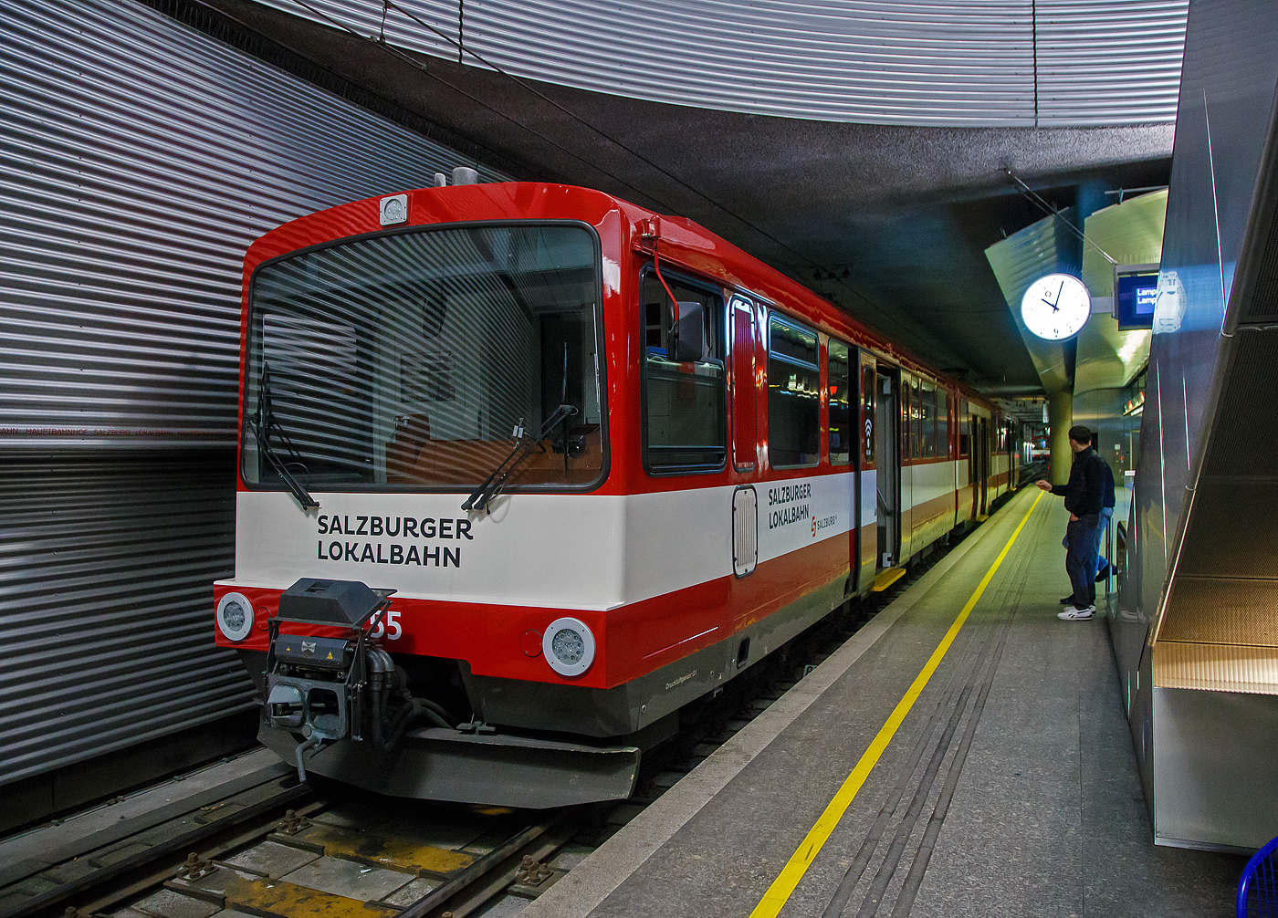 Der ET 55 „Land Salzburg“ (Baujahr 2001) der SLB - Salzburger Lokalbahn steht am 12.09.2022 im Hbf Salzburg (tief). 

Der Triebwagen wurde 2001 von Siemens (ex SGP - Simmering-Graz-Pauker AG) gebaut, der elektrische Teil ist von Bombardier (ex AEG).

Seit 1983 bestimmen die bis 2002 beschafften Stadtbahnwagen der Typenreihe ET40 (ET40HF und ET40NF) das Bild der Salzburger Lokalbahn. Diese waren nach über 30 Jahren die ersten Neufahrzeuge und setzten ein Zeichen für Aufschwung des Nahverkehrs im nördlichen Flachgau und im angrenzenden Innviertel.

Nach Abwägung mehrerer Projekte entschied sich die SLB in Anlehnung an deutsche Stadtbahnwagen sechsachsige Gelenktriebwagen zu beschaffen. So geschah es, dass 1983 der erste Triebwagen einer zunächst fünf Fahrzeuge umfassenden Lieferserie (ET41-ET45) in Salzburg eintraf und sich sofort großer Beliebtheit erfreute. Das Konzept dieser Triebwagen bewährte sich, sodass ab 1988 eine weitere Serie (ET46-ET50) in Betrieb genommen wurde. Diese Triebwagen wiesen einige Modifikationen auf, die sich jedoch äußerlich kaum bemerkbar machen.

Infolge der stetig wachsenden Fahrgastzahlen und um die letzten Altbautriebwagen aus dem Planbetrieb nehmen zu können, wurden 1992 vier Triebwagen (ET51-ET54) und 2001/02 weitere vier (ET55-ET58) ausgeliefert. Die Triebwagen ET50 bis ET58 wurden von 2012 bis 2014 mit Niederflur-Mittelteilen zu achtachsigen Fahrzeugen umgebaut. Als erstes Fahrzeug wurde ET54 im Juli 2012 nach dem Umbau durch die Firma INEKON in Ostrava (CZ) in Salzburg übernommen. 

Die beiden Wagenkästen eines Triebwagens stützen sich stirnseitig über Schraubenfedern auf die Drehgestelle ab. Diese sind als Triebdrehgestelle ausgeführt, welche je einen Gleichstrommotor aufnehmen. Die Kraftübertragung erfolgt mittels starrer Wellen und Achsgetrieben auf beide Achsen eines Drehgestells. Jede der acht Achsen ist mittels Maggy-Federn mit dem Drehgestell verbunden. Jede Achse der Triebdrehgestelle wird mit Federspeicherbremsen gebremst. Als primäre Betriebsbremse dient eine elektrische Bremse, als Zusatzbremse dienen Magnetscheibenbremsen an jedem Drehgestell. Die Laufdrehgestelle werden mit Druckluftbremsen gebremst. Durch entsprechende elektronische Ansteuerung können die Triebwagen in Vielfachsteuerung (max. drei Fahrzeuge) eingesetzt werden.

Mechanischer Teil
Der Wagenkasten ist als selbsttragende Stahlkonstruktion ausgeführt welche sich auf den beiden Motordrehgestellen an den Fahrzeugenden sowie auf Jakobs-Drehgestelle abstützt. Der Fahrmotor ist den Drehgestellen als Längsmotor eingebaut, die Kraftübertragung erfolgt über Winkelgetriebe (Tandemantrieb). Die Primärfederung wurde mittels Megi-Federn ausgeführt, zwischen Drehgestell und Wagenkasten kommen Schraubenfedern in Verbindung mit hydraulischen Stoßdämpfern zum Einsatz. Die Wagen 50–58 wurden in den Jahren 2012–2014 um ein Niederflur-Mittelteil erweitert und ein zusätzliches Jakobs-Drehgestell erweitert. Des Weiteren wurden in den Endwagen Sitze und Bodenbeläge getauscht sowie die Drehfalttüren durch Schwenkschiebetüren der Firma IFE ersetzt. Das Umbauprogramm wurde 2019 mit dem ET46 abgeschlossen. Somit sind von den 18 Triebwagen insgesamt 13 mit Mittelteil (ET46-ET58, Bezeichnung ET40NF) ausgestattet und 5 Fahrzeuge (ET41-ET45) noch wie ursprünglich 2-teilig. 

Elektrischer Teil
Die Fahrmotoren sind als vierpolige, kompensierte Vollspannungs-Reihenschlussmotoren mit 300 kW Nennleistung ausgeführt. Jeder Motor wird von einem eigenen Thyristor-Gleichstromsteller (Chopper) angesteuert. Durch die Verwendung von Gleichstromstellern ist es möglich, Bremsenergie in die Fahrleitung zurück zu speisen. Kann die Bremsenergie nicht aufgenommen werden, wird diese durch Bremswiderstände in Wärme umgewandelt. 

TECHNISCHE DATEN:
Gebaute Anzahl: 9 (ET 46 bis ET 58)
Spurweite:  1.435 mm (Normalspur)
Achsfolge:  B‘2‘2‘B‘
Länge über Puffer: 38.800 mm
Höhe mit Dachaufbauten: 3.720 mm
Breite: 2.674 mm
Fußbodenhöhe über SOK: 984 mm, im Niederflur-Mittelteil 350 mm
Leergewicht: 62.700 kg
Drehzapfenabstand: 3 x 10.400 mm
Achsstand im Drehgestell: 1.900 mm
Raddurchmesser:  780 mm (neu) / 710 mm (abgenutzt)
Kleinster zulässiger Bogenradius:  80 m
Höchstgeschwindigkeit: 80 km/h
Sitzplätze: 104
Stehplätze: 158
Leistung Fahrmotoren:  2 x 300 kW 
Übersetzung: 1:5,625
Stundenleistung:  600 kW
Fahrdrahtspannung : 1.000 V DC (=)
Steuerung:  Chopper (Gleichstromsteller)
Stromabnehmer:  Halbscherenstromabnehmer
Zug- und Stoßvorrichtung: Scharfenbergkupplung
Bremsbauart: Elektrodynamische Nutzbremse, Federspeicher-, Magnetschienen- und Solenoidbremse

Die SLB ist eine Tochtergesellschaft der Salzburg AG für Energie, Verkehr und Telekommunikation. Die Bahn nahm 1896 ihren Betrieb auf. Von 1907-1940 betrieb die Salzburger Eisenbahn und Tramway Gesellschaft (SETG) die Bahn, die in der Stadt Salzburg auch ein Straßenbahnnetz betrieb.

Quelle: SLB