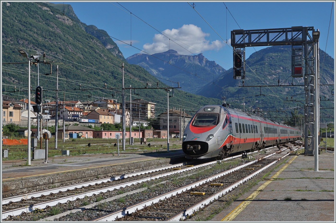 Der FS Trenitalia ETR 610 011 (und ein nicht zu sehender SBB ETR 610/RABe 503) erreichen als EC 51 (Basel SBB - Milano) den Bahnhof von Domodossola. 

25. Juni 2022