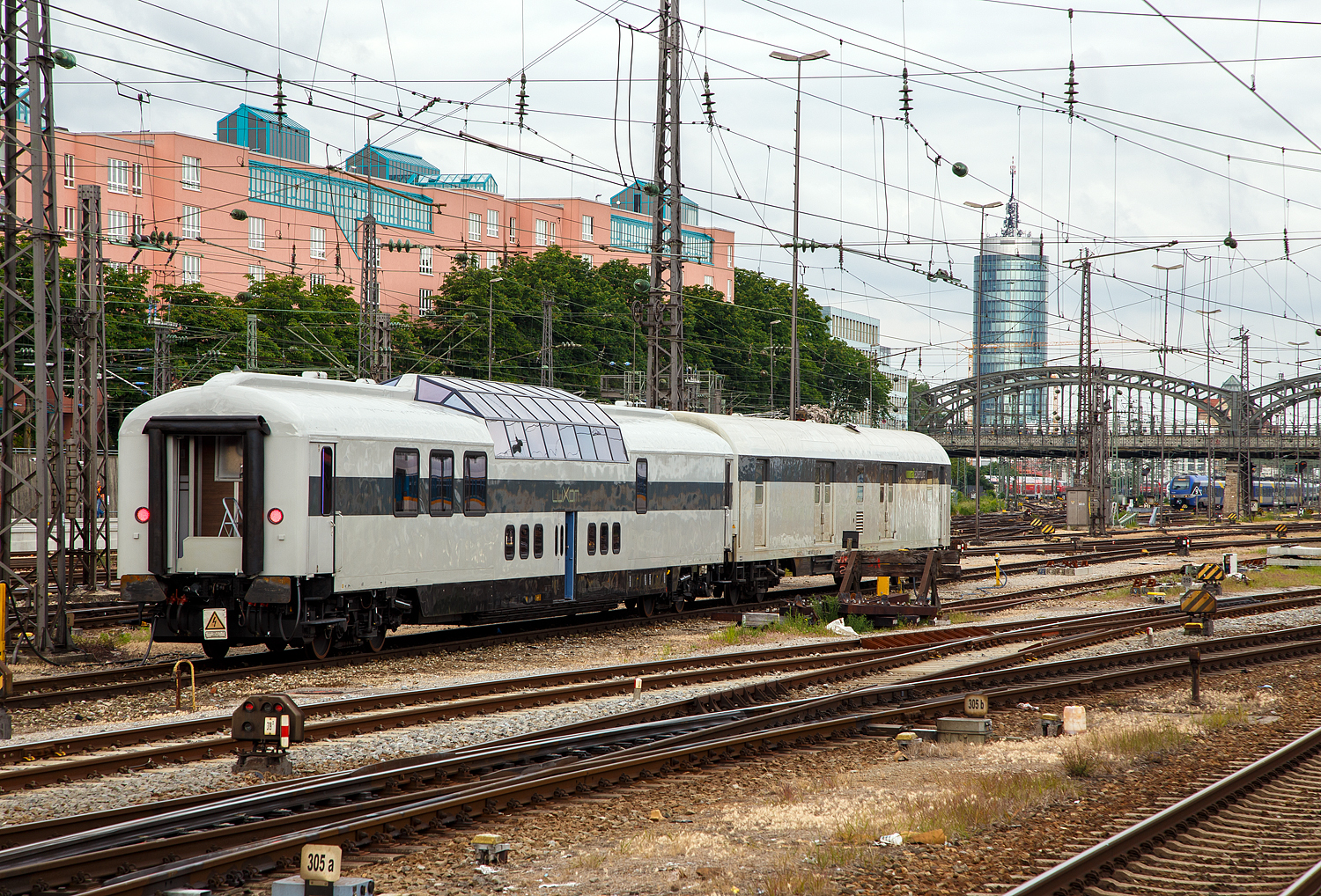 Der LUXON DomeCar CH-RADVE 61 85 89-90 003-3 SRmz der Rail Adventures ist dem Schutzwagen (Begleitwagen) D-RADVE 56 80 90-91 001-5 Dmz 090 der RailAdventure, ex DBP 51 80 00-95 189-8 Post 026, am 06.05.2019 beim Hauptbahnhof München abgestellt.

Bei dem Begleitwagen (Schutzwagen für Überführungsfahrten) handelt es sich um den ehemaligen Schnellzug-Bahnpostwagen Dmz 090 der Deutschen Bundespost (DBP) 51 80 00-95 189-8 Dmz 90 (ex Post 026), Post-Nr. 73 189. Gebaut wurde der Wagen 1975 von Wegmann & Co. in Kassel für die DBP gebaut. Nach der Ausmusterung 1997 bis 2017 gehörte er der Eifelbahn Verkehrsgesellschaft (EVG). 
2012 sah der Begleitwagen noch so aus:
https://hellertal.startbilder.de/bild/deutschland~wagen~gepackwagen---bahnpostwagen/223715/schnellzug-bahnpostwagen-der-deutschen-bundespost-mrz-post-nr.html

Bei dem Aussichtswagen CH-RADVE 61 85 89-90 003-3 SRmz, handelt es sich um den ehemaligen DomeCar  DB 10 433 AD4üm-62 für den Fernschnellzug Rheingold (F-Zug), der 1962 von Wegmann & Co. in Kassel gebaut wurde. Ab 1966 DB 10 533 AD4ümh 101und später DB 61 80 88-80 003-8 ADmh 101.
Fünf dieser Aussichtswagen im Stil der US-amerikanischen Domecars wurden von Wegmann für die Deutschen Bundesbahn (DB) gebaut, die sie für luxuriösen Fernschnellzug Rheingold, der ausschließlich die 1. Klasse führte, beschaffte. Zwei für jedes Zugpaar und ein weiterer Wagen als Betriebsreserve.

1963 wurden zwei nahezu baugleiche Wagen für den Rheinpfeil in Betrieb genommen, äußerlich an den größeren Panoramafenstern (vier statt acht) erkennbar. Sie hatten die abweichende Gattungsbezeichnung AD4üm-63, außerdem trugen sie ursprünglich statt des Rheingold-Schriftzuges die Anschrift „Deutsche Bundesbahn“. 1965 wurden beide Züge zu Trans-Europ-Express-Zügen (TEE) heraufgestuft.

Ab 1971 wurden die TEE-Züge in Deutschland weitestgehend in das neu geschaffene Intercity-Netz integriert und der fahrplanmäßige Einsatz der Aussichtswagen 1973 beendet. 1976 wurden sie an die Internationale Apfelpfeil-Organisation (IAO), einen Reiseveranstalter, verkauft. Die IAO baute die Kuppeln um und verringerte deren Höhe um 20 cm, was den Fahrzeugen ein Lichtraumprofil gab, das deren freizügigen Einsatz in ganz Europa ermöglichte. Als die IAO in die Insolvenz fiel, kaufte das Reisebüro Mittelthurgau die Fahrzeuge, ertüchtigte sie für den Einsatz mit 200 km/h und vermarktete mit ihnen Schienenkreuzfahrten unter der Marke TEE Panorama. Anschließend wurden sie an die Veolia-Tochter Tågkompaniet verkauft, die sie von 1999 bis 2002 zwischen Stockholm und Narvik verkehren ließ. Dann wurden die Wagen einzeln an unterschiedliche Eigentümer veräußert:

Nr. 10551 kam 2005 zu einem Reiseveranstalter in den Niederlanden.
Nr. 10552 übernahm der Freundeskreis Eisenbahn Köln und unterhält ihn betriebsfähig.
Nr.10554 wurde ebenfalls von der VEB übernommen, später von der AKE-Eisenbahntouristik gekauft und dort im AKE-Rheingold eingesetzt.
Nr. 10555 übernahm die Deutsche Bahn Stiftung, Trägerin der Museen der DB AG. Er steht als Info-Zentrum im Güterbahnhof Coburg.

Dieser hier war, Nr. 10553 wurde zunächst von der Vulkan-Eifel-Bahn Betriebsgesellschaft (VEB) übernommen. Im April 2011 kaufte ihn das Eisenbahnverkehrsunternehmen RailAdventure für 40.000 Euro, sanierte ihn in mehrjähriger Arbeit grundlegend und baute ihn dabei zu einem modernen Salonwagen um. Das Fahrzeug wurde auf der InnoTrans 2012 in Berlin vorgestellt, absolvierte anschließend Testfahrten und kann nun seit 2019, in gut 100.000 Arbeitsstunden nach 95 Monate Umbau und ein paar Millionen Euro Kosten, gemietet werden. Er ist heute in der Schweiz zugelassen und trägt die Bezeichnung SRmz 61 85 8990 003-3.

Luxon bringt Luxus auf die Schienen
Die Rail Adventures haben aus diesem Panoramawagen ein Wunderwerk gebaut. Der Komfort des 21. Jahrhunderts in einem legendären Eisenbahnschmuckstück. Für eine Spritztour mit dem Luxuszug muss man nur solvent sein, denn unter 11.000 Euro kann man den Luxuszug leider nicht buchen.
Bis zu 22 Gäste können zukünftig vom Bahnhof ihrer Wahl auf ihrer Wunschstrecke in einem Sonderzug der besonderen Art verreisen: Der sogenannte Luxon fährt bis zu 200 Kilometer pro Stunde. Sein Panoramadeck kann durch flexible Bestuhlung für geschäftliche Anlässe in einen fahrenden Konferenzraum verwandelt werden. Elf elektrisch verstellbare Liegesessel für die Aussichtskuppel gibt es außerdem. Doch unabhängig davon, zu welchem Anlass der Luxon gebucht wird, 2-Sterne-Koch Tohru Nakamura verwöhnt die geladenen Gäste kulinarisch auf höchstem Niveau. Siebengängige Menüs für bis zu 22 Gäste sind möglich. Ab 11.000 Euro kann der Luxon gebucht werden. Der Preis hängt von Personenanzahl, Strecke und Art des Events ab.

TECHNISCHE DATEN (DomeCar):
Spurweite: 1.435 mm
Anzahl der Achsen: 4 in 2 Drehgestellen
Länge über Puffer: 26.400 mm
Drehzapfenabstand: 19.000 mm
Eigengewicht: 53 t
Höchstgeschwindigkeit: 200 km/h
