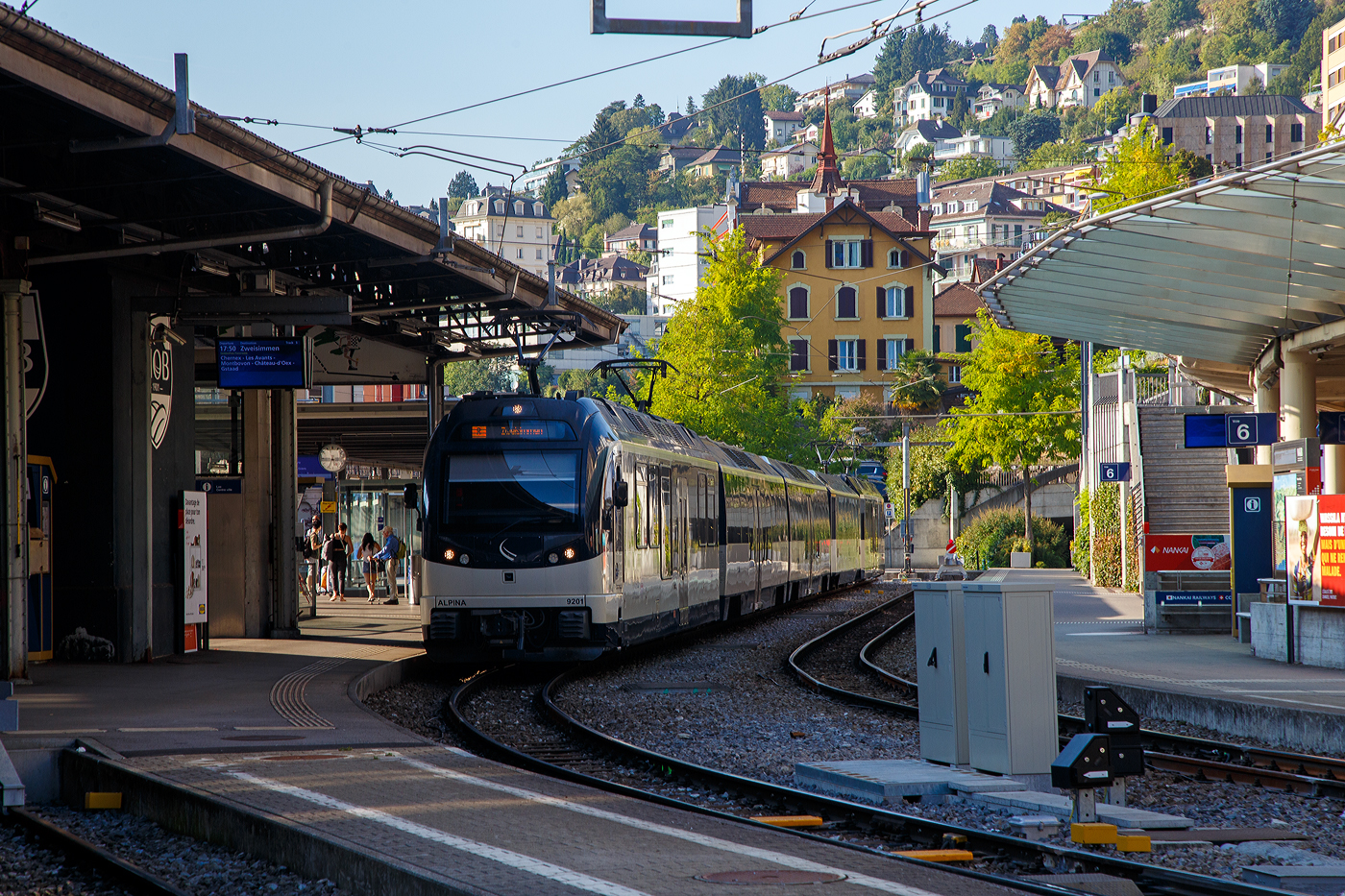 Der MOB Regionalzug nach Zweisimmen steht am 10 September 2023 im Bahnhof Montreux zur Abfahrt bereit. Der Zug besteht hier aus dem MOB ALPINA 9201 bzw. Be 4/4 9201, dazwischen drei normalen (konventionellen) Personenwagen und am Schluss den MOB ALPINA 9301 bzw. ABe 4/4 9301.

Die vier von Stadler 2016 gebauten MOB Alpina-Triebzüge ABe 8/8 9000 sind modular einsetzbar. Ein Triebzug besteht jeweils aus einem Be 4/4 9200er und einem ABe 4/4 9300er Triebwagen. So können sie (wie hier mit 2) mit bis zu neun (hier 2) bestehenden Zwischenwagen ergänzt werden.

Die MOB (Montreux–Berner Oberland-Bahn) bestellt Ende 2013 diese Triebzüge bei Stadler Rail, da die ABDe 8/8 Doppeltriebwagen der Serie 4000, die lange Zeit das Rückgrat der Zugförderung auf der Strecke Montreux – Zweisimmen waren, an der Leistungsgrenze waren um den Bedürfnissen des Verkehrs gerecht zu werden. Auch die Geschwindigkeit und Beschleunigung sind unzureichend. Die neuen Triebwagen können sowohl für die Traktion von schwere Züge (bis zu 9 Wagons), sowie für Solofahrten außerhalb der Hauptverkehrszeiten, was ihre optimale Nutzung mit bis zu vier Umläufen zwischen Montreux und Zweisimmen ermöglicht. Diese dynamischen und zeitgemäßen Züge sind einladend und komfortabel für Reisende (obwohl wir wohl lieber die ABDe 8/8 4000 sehen würden). Sie reagieren technologisch auf schwierige Betriebsbedingungen, aber auch auf Erwartungen Kunden (Reisende).

Technische Merkmale:
-Wagenkasten aus Aluminium-Strangpressprofile für eine höhere Lebensdauer und leichtere Instandhaltung bei gleichzeitig geringerem Fahrzeuggewicht.
- Luftgefederte Drehgestelle sorgen für noch mehr Komfort und eine verbesserte Laufruhe
- Mehrfachtraktion mit bis zu 3 Doppeltriebwagen
- Rekuperationsbremse / dynamische und elektromagnetische Bremse
- 2 Eingänge pro Seite für einen schnellen Fahrgastwechsel
- Behindertengerechte Zugangsmöglichkeiten
- Behindertengerechtes geschlossenes WC-System

TECHNISCHE DATEN (als Triebzug ohne Zwischenwagen):
Fahrzeugbezeichnung: ABe 8/8 (ABe 4/4 + Be 4/4)
Anzahl Fahrzeuge: 4 (je 4 ABe 4/4 und Be 4/4)
Inbetriebsetzung: 2016
Spurweite: 1.000 mm
Achsanordnung: Bo’Bo’ + Bo’Bo’
Länge über Kupplung: 40.920 mm
Fahrzeugbreite: 2.650 mm
Fahrzeughöhe: 3.850 mm
Drehzapfenabstand:12.830 mm
Achsstand im Drehgestell: 2.000 mm
Treibraddurchmesser (neu): 810 mm
Höchstgeschwindigkeit: 100 km/h
Dauerleistung am Rad: 2 x 1.020 kW
Maximalleistung am Rad: 2 x 1.400 kW
Anfahrzugkraft: 300 kN (bis 35 km/h)
Speisespannung: 960 V DC (Gleichstrom)
Maximale Anfahrtsbeschleunigung: 1,2 m/s²
Maximale Bremsverzögerung: 1,33 m/s²
Kleister befahrbarer Gleisbogen: R = 47 m
Sitzplätze: 1. Klasse 18 / 2. Klasse 55 und 8 Klappsitze
Stehplätze (4 Pers./m²): 125
Fußbodenhöhe: Niederflur 400 mm / Hochflur 1.040 mm
Einstiegbreite: 1.300 mm
Kasten-Längsdruckkraft: 800 kN

Quelle: Stadler Rail (französisch)