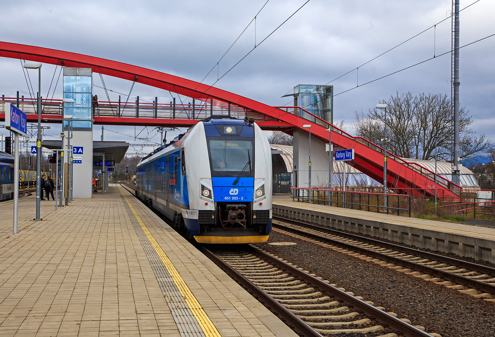 Der RegioPanter 651 203-2 / 650 203-3 (CZ-ČD 94 54 1 651 203-2  / CZ-ČD 94 54 1 650 203-3), ein zweiteiliger Zweisystem-Elektrotriebzug (3 kV DC und 25 kV, 50 Hz~) vom Typ ¦koda 15 Ev, der České dráhy (ČD) / Plzeňský Kraj (deutsch Pilsner Region) verlässt am 18.04.2023, als Sp nach Pilsen (Plzeň) via Cheb (Eger), den Bahnhof Karlovy Vary (Karlsbad oberer Bahnhof).

Der zweiteiliger zweisystemfähiger (3 kV DC und 25 kV, 50 Hz~) Elektrotriebzug vom Typ ¦koda 15Ev/HV14 wurde 2021 von ¦koda Vagonka a.s. in Ostrava (ex ČKD Vagónka Studénka) gebaut.

Die einstöckigen Elektrotriebzüge RegioPanter stellen eine völlig neue Generation von modernen Niederflur-Fahrzeugen dar. Sie werden mit einem Stromsystem (3 kV DC) und mit zwei Stromsystemen (3 kV DC und  25 kV / 50 Hz AC) bei der wie die hier gezeigten BR 650 / 651 angeboten. Die ČD hat zwei- und dreiteilige Einheiten bestellt, laut Hersteller sind bis zu sechsteilige Kompositionen möglich. Bis zu vier Wagenzüge sind kuppelbar. Die BR 650.2 / 651.2 werden als Typ ¦koda 15 Ev und sind gegenüber der BR 650.0 / 651.0 (¦koda 7 Ev) modifiziert. Beide Wagenteile sind jeweils mit einem Triebdrehgestell mit zwei Asynchronmotoren und einem üblichen Laufdrehgestell ausgestattet. Im Vergleich zu den vorhanden Zwei-Wagen-Zügen verbraucht der Zug RegioPanter bis um eine Hälfte  weniger Strom, und zwar auch dank des Systems der Energierückgewinnung, die beim Bremsen entsteht. Die einstöckige regionale Einheit ist als ein völlig durchgängiger Zug konzipiert, d.h. ohne Innenzwischenwände und Türen.  Offen ist auch der Übergang zwischen den Wagen. Die meiste elektrische Ausrüstung befindet sich auf dem Dach, wodurch sich der Fahrgastraum erheblich erweitert. Die Drehstrom-Traktionsmotoren vom Typ ¦koda ML 3942 K/4 besitzen eine Leistung von je 340 kW.

TECHNISCHE DATEN:
Spurweite: 1.435 mm
Achsformel: Bo‘2‘+2‘Bo‘
Länge über Kupplung: 52.900 mm
Breite: 2.820 mm
Höhe: 4.260 mm
Drehzapfenabstand: 19.000 mm
Achsabstand im Drehgestell: 2.400 mm
Raddurchmesser: 850 (neu) / 770 mm (abgenutzt)
Dauerleistung: 1.360 kW (4 x 340 kW)
Höchstgeschwindigkeit: 160 km/h 
May. Beschleunigung: 1,1 m/s²
Stundenzugkraft: 131 kN
Kleinster befahrbarer Gleisbogen: 125 m
Stromsystem: 3 kV DC und  25 kV / 50 Hz AC
Leergewicht: 102,8 t
Anzahl der Sitzplätze: 140, davon  8 in der 1. Klasse
Anzahl der Stehplätze: 183
Plätze für Fahrräder/Kinderwagen: 9 / 4
