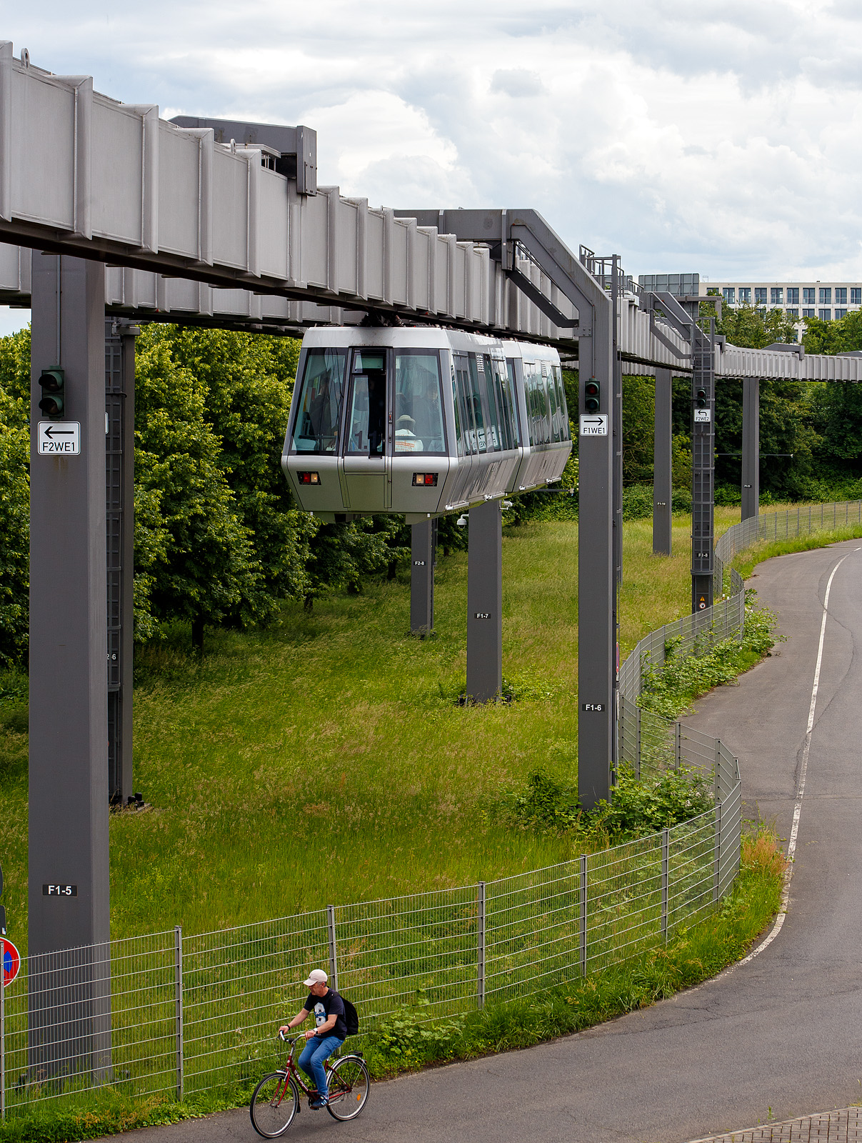 Der SkyTrain Düsseldorf Flughafen, ein Zug (zwei aneinander gekoppelten Kabinen) erreichen am 26 Mai 2024, vom Terminal.kommend, die Station Fernbahnhof.

Die vollautomatische Kabinenbahn (fahrerloser Betrieb), die rund 2,5 km lange doppelgleisige Strecke verläuft in etwa 10 Metern Höhe.  Der SkyTrain bringt einen in sieben Minuten (mit bis zu 50 km/h) vom Fernbahnhof zum Terminal. Die Haltestellen sind der Bahnhof Düsseldorf Flughafen, das Parkhaus P4/P5, das Terminal A/B sowie das Terminal C. Die Haltepunkte werden auf Deutsch und Englisch angesagt. Alle Kabinen verfügen über großflächige Panoramafenster und ausreichenden Stauraum für Gepäck. Die Kabinen besitzen außenliegende Schiebetüren und Überstiegstüren an den beiden Stirnseiten.

In Deutschland ist das System der Straßenbahn-Bau- und Betriebsordnung (BOStrab) unterworfen und gilt nach § 4 Abs. 2 PBefG als (vom sonstigen Verkehr) unabhängige Bahn, die dementsprechend auch automatisch, d. h. ohne Fahrpersonal in den Fahrzeugen, betrieben werden darf.

SkyTrain Düsseldorf verfügt über 6 Züge mit je 2 festgekuppelten Kabinen sowie1 Sonderfahrzeug. Die Beförderungskapazität beträgt rund 2.000 Fahrgäste pro Stunde und Richtung, ca. 90 Fahrgäste pro Zug.

Basierend auf der von Siemens Transportation Systems entwickelten Hängebahn-Technologie bestehen die Fahrzeuge aus den Hauptkomponenten Kabine und Fahrwerke.

Eine Kabine ist über vier niveaugeregelte Luftfedern mit hydraulischer Dämpfung an den beiden Fahrwerken befestigt. Die tragende Kabinenstruktur wurde aus hochfesten Aluminium-Strangpreßprofilen aufgebaut, die sich durch hohe Korrosionsfestigkeit und Steifigkeit bei niedrigem Gewicht auszeichnet. Im Inneren der Kabine befinden sich neben 15 Sitz- und 32 Stehplätzen für die Fahrgäste auch alle Betriebsmittel zur Steuerung und Überwachung der Fahrzeugkomponenten. Diese sind in speziellen Geräteschränken untergebracht. Im Bedarfsfall können die Fahrzeuge auch im Handbetrieb mit Fahrern gesteuert werden.

Seit dem 1. Juli 2002 ist der SkyTrain am Flughafen Düsseldorf im Betrieb. Baubeginn war im November 1996. Zuerst wurde der Abschnitt zwischen dem Fernbahnhof und dem Terminal A/B in Betrieb genommen. Diese Strecke ist 2,5 Kilometer lang und weist bis zu 4 % Steigung auf. Der letzte, rund 250 Meter lange Abschnitt bis Terminal C wurde rund 1½ Jahre später mit der Fertigstellung des Terminals eröffnet. Die Baukosten beliefen sich auf rund 150 Millionen Euro, von denen der Flughafen-Bahnhof 35 Millionen Euro verschlang. 62 % der Baukosten wurden durch Fördermittel erbracht.

Auf der Strecke verkehren bis zu sechs Züge aus je zwei aneinander gekoppelten Kabinen, die je 18,4 Meter lang und 2,56 Meter breit sind und mit einer Spannung von 400 Volt betrieben werden. Jeder Zwei-Wagen-Zug bietet 64 Steh- und 30 Sitzplätze. Bei einem Dreiminutentakt befördert die Bahn bis zu 2000 Fahrgäste in der Stunde, jeweils von 3:45 Uhr bis 0:45 Uhr. Die Strecke wird mit einer Reisegeschwindigkeit von 21 km/h im Schnitt in sieben Minuten durchfahren, die Höchstgeschwindigkeit beträgt 50 km/h.

In ihrer Anfangsphase hatte die Bahn mehrfach Probleme mit der sensiblen Auslegung der Sicherheitssysteme, die unbegründete Notbremsungen auf offener Strecke zur Folge hatten. Dies führte phasenweise zur Einstellung des Betriebs. Am 7. Dezember 2006 wurde der SkyTrain vom Flughafen endgültig abgenommen. Nach Aussage des Flughafens wurde vor der Abnahme eine Verfügbarkeit des Systems von über 99 % nachgewiesen. Siemens bleibt Betreiber der Anlage und haftet auch für weitere Ausfälle der Bahn über die Gewährleistungszeit von 25 Jahren.

ANTRIEBSSYSTEM
Die vier Gleichstrommotoren werden über thyristorgesteuerte Stromrichtergeräte betrieben. Die Spannungsversorgung erfolgt mit 400 Volt aus dem Drehstromnetz. Die Bremsenergie wird in das Versorgungsnetz zurückgespeist und damit den anderen Fahrzeugen zur Beschleunigung bzw. zum Fahren zur Verfügung gestellt.

Die von einem Fahrzeug aufgenommene Spitzenleistung beträgt 225 kVA. Die beiden Fahrwerke (einer Kabine) laufen auf 4 gummibandagierten Trag- und Treibrädern in einem kastenförmigen Fahrweg-Träger (einem unten geschlitzten Hohlkastenträger) und werden von 16 Führungsrollen mit Hartgummibandagen (je 4 Doppelrollen vorne und hinten) geführt und somit in der Spur halten. Es ist damit wesentlich komplexer aufgebaut als ein Fahrwerk der Wuppertaler Schwebebahn, das aus lediglich 2 Rädern besteht. Im Innern des Fahrbahnträgers (Hohlkastenträger) laufen die Fahrwerke weitgehend witterungsgeschützt, zudem sind so die Führung und Stromversorgung wettergeschützt.Das Antriebssystem eines Fahrzeuges besteht aus zwei weitestgehend unabhängigen, redundanten Einheiten, die wiederum über je zwei parallelgeschaltete Fahrmotoren verfügen. Beim Ausfall eines Systems kann die Fahrt also bis zur Endhaltestelle fortgesetzt werden.

Die Stromabnahme läuft über vier seitlich angebrachte Stromschienen, dabei wird Dreiphasenwechselstrom (Drehstrom) mit einer Spannung von 400 Volt übertragen, der ohne Umformer und eigene Umspannstationen direkt aus dem Drehstromnetz genommen wird. Darüber liegen Linienleiter zur drahtlosen Übertragung von Daten zwischen Fahrzeug und Leitstand.

Weichen ermöglichen Verzweigungen des Fahrwegs. Bahnsteigtüren verhindern Abstürze aus hoch gelegenen Bahnhöfen bzw. ein Betreten der Gleisbereiche.

Die H-Bahn wird von einer zentralen Leitstelle aus überwacht und kommt so ohne Fahrpersonal in den Zügen aus. Sie könnte auch je nach Auslastung, im Takt- oder im Rufbetrieb eingesetzt werden, wobei im letzteren der Fahrgast sich die Kabine wie einen Personenaufzug per Knopfdruck „bestellt“.

TECHNISCHE DATEN DES ANTRIEBS: 
Fahrspannung: 3 x 400 V, 50 Hz
Nennleistung Fahrmotoren: 4 x 31,5 kW
Drehzahlbereich: 0..3290 U/min
Nenndrehmoment:  4 x 90 Nm
Antriebskraft (Nennwert): 8,4 kN
Antriebskraft (Anfahrzugkraft): 16,8 kN
betriebliche Beschleunigung: 1 m/s²
betriebliche Verzögerung: 1 m/s²
Sicherheitstechnische Verzögerung: > 1,5 m/s²
Höchstgeschwindigkeit: 13,9 m/s (50 km/h)
Positioniergenauigkeit: ± 3 cm
Fahrgeräusch (bei 50 km/h in 25 m Entfernung) < 65 dB/A

TECHNISCHE DATEN einer Kabine:
Länge über Kupplungen:  9.200 mm
Länge der Kabine: 8.232 mm
Breite der Kabine: 2.244 mm
Höhe der Kabine: 2.623 mm
Lichte Weite eine Fahrgasttür: 1.350 mm (2x je Längsseite einer Kabine)
Mittenabstand Fahrgasttüren: 4.600 mm
Mittenabstand Fahrwerke: 5.689 mm
Gewicht eines Fahrwerks: 1.750 kg
Leergewicht einer Kabine : 4.955 kg
Leergewicht Fahrzeug: 8.455 kg (1 Kabine mit 2 Fahrwerken)
Zuladung (nach BOStrab): 4.923 kg
zulässiges Gesamtgewicht: 13.378 kg
Sitzplätze: 15
Stehplatze: 32