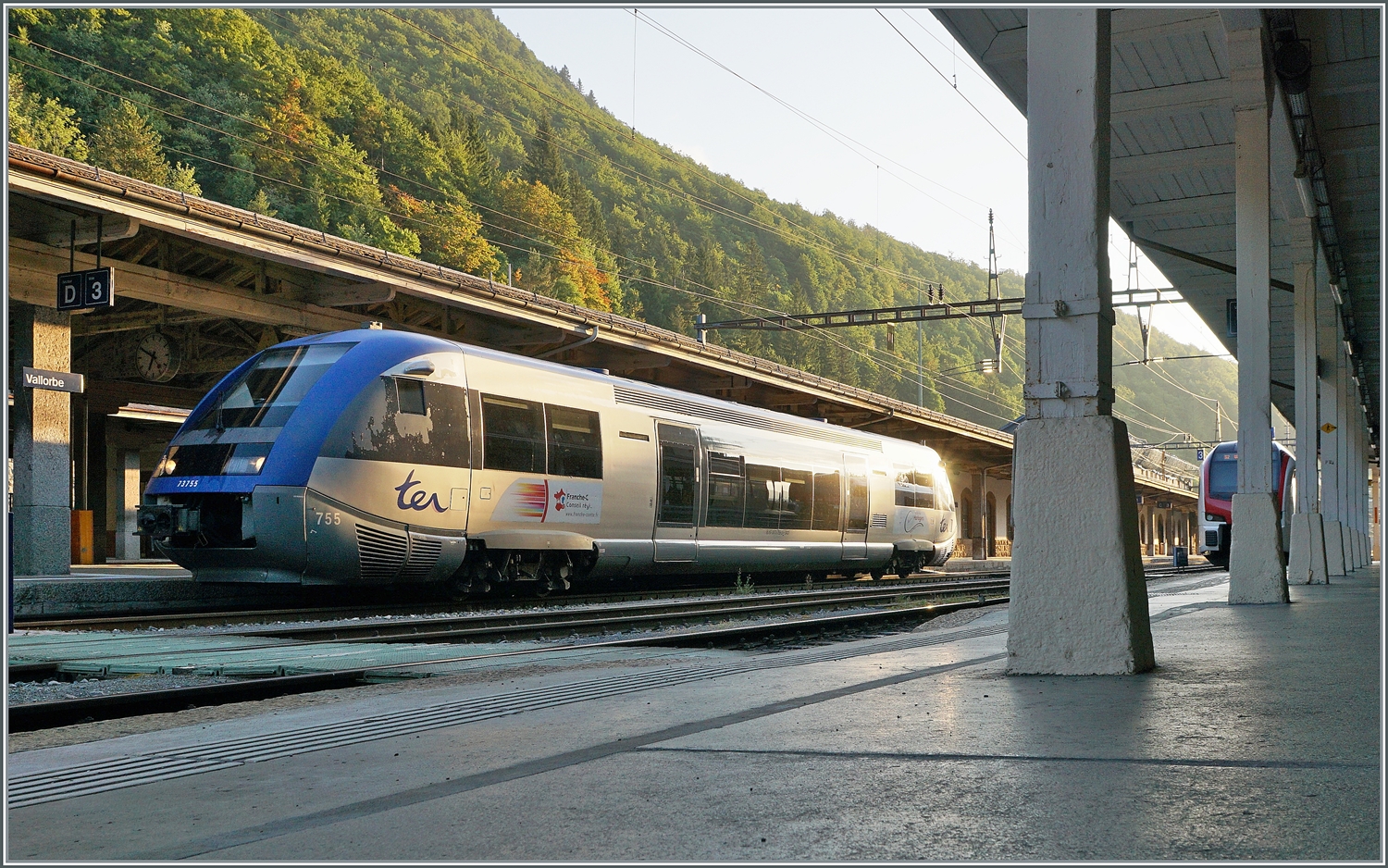 Der SNCF X 73755 wartet als TER 18136 in Vallorbe auf die Abfahrt nach Frasne. Links im Bild kaum erkennbar steht ein SBB RABe 523.1 der als S2 von Aigle angekommen ist und für die Rückfahrt verstärkt wird, dies ist insofern von Bedeutung, dass die Verstärkungskomposition an diesem Tag nicht schon bereit stand und mir die Sicht, bzw, das Foto auf den SNCF X 73355 verwehrte. Im Übrigen ist dem angeschnitten Schild  Überschreiten der Geleise verboten  absolut Beachtung zu schenken, der Gang durch Unterführung ist eine Reise in eine längst vergessen geglaubte Welt. 

21. Juli 2022