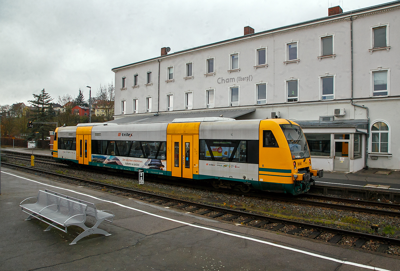 Der Trilex VT 067 alias 650 067-1 (95 80 0650 067-1 D-DLB) ein STADLER Regio-Shuttle RS1 der „oberpfalzbahn“ eine Marke der „Die Länderbahn GmbH (DLB)“, steht am 22.11.2022 in Cham (Oberpfalz), als RB 29 (ex OPB 5) nach Waldmünchen, zur Abfahrt bereit. Dieser ist hier noch in „trilex“-Farbgebung, die auch zur „Die Länderbahn GmbH (DLB)“ gehört.

Die 13 STADLER Regio-Shuttle RS1 (Baujahr 2000/03) der „oberpfalzbahn“ wurden 2013/2014 modernisiert (komplett entkernt und umgebaut). Für die kleinen Fahrgäste ist eine Kinderspielecke entstanden. Verbessert wurde auch die Fahrgastinformation im Fahrzeug. Neue Monitore wurden im Bereich des Aus- und Einstiegs eingebaut und informieren über den aktuellen Verlauf der Fahrt und die weiteren Anschlüsse. Zwei Mehrzweckbereiche pro Fahrzeug bieten ausreichend Platz für bis zu sechs Fahrräder, Kinderwagen und Gepäck. Der stufenlose Einstieg ermöglicht auch mobilitätseingeschränkten Personen einen bequemen Zugang. Das Fahrzeug bietet Platz für ca. 155 Fahrgäste (72 Sitzplätze). 

Der Antrieb erfolgt über 2 MAN Dieselmotoren mit je 257 KW (350 PS) Leitung hydromechanisch über 2 Voith-Diwabus Getriebe U 864, die Höchstgeschwindigkeit beträgt 120 km/h.