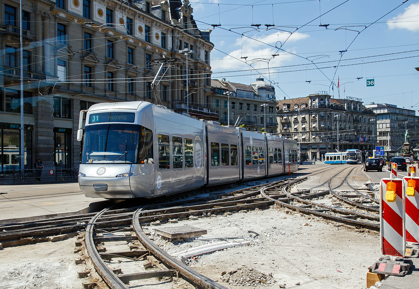 Der VBZ - Tram Be 5/6 3018, ein fünfteiliger Bombardier Cobra, als Linie 11 am 07 Juni 2015 auf den Baugleisen am Bahnhofplatz in Zürich. 