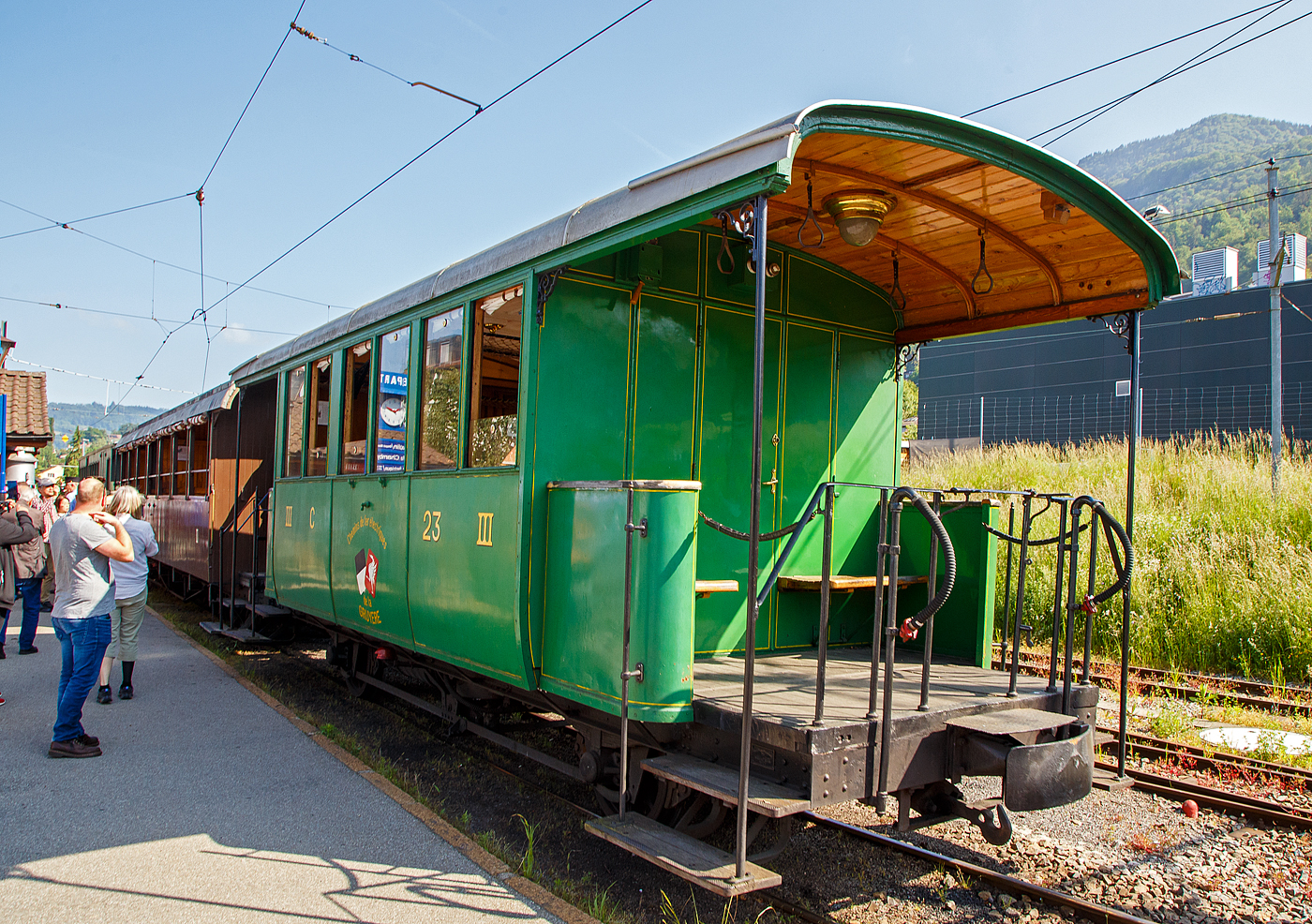 Der zweiachsige 3. Klasse Personenwagen mit offenen Plattformen (Plattformwagen) ex CEG C 23 (Chemins de fer Electriques de la Gruyère, ab 1942 GFM - Chemins de fer fribourgeois Gruyère–Fribourg–Morat) der Museumsbahn Blonay-Chamby am 27.05.2023 im Zugverband im Bahnhof Blonay.

Der Wagen wurde 1903 von der SWS (Schweizerische Wagons- und Aufzügefabrik AG, Schlieren) für die Chemins de fer électriques Veveysans (CEG) gebaut und als CEG C² 23 geliefert. Im Jahr 1967 ging der Wagen an die Museumsbahn Blonay-Chamby.

Die Chemins de fer électriques de la Gruyère schloss sich 1942 mit den beiden Normalspurbahnen FMA und BR zur GMF (Chemins de fer fribourgeois Gruyère–Fribourg–Morat) zusammen. Seit 2000 nun TPF (Transports publics fribourgeois SA / Freiburgische Verkehrsbetriebe AG).

TECHNISCHE DATEN:
Baujahr: 1903
Hersteller: SWS Schlieren (Schweizerische Wagons- und Aufzügefabrik AG)
Spurweite: 1.000 mm (Meterspur)
Achsanzahl: 2
Länge über Puffer: 8.900 mm
Länge Wagenkasten: 7.900 mm (mit Plattformen)
Achsabstand: 4.300 mm
Eigengewicht: 7,3 t
Sitzplätze: 23 in der 3. Klasse