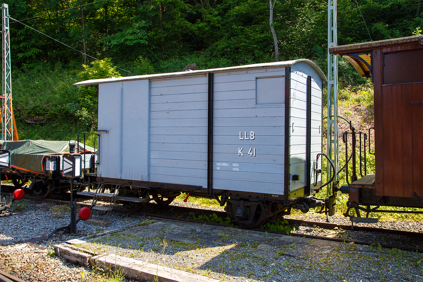 Der zweiachsige gedeckte Güterwagen mit einer Bremserbühne ex LLB K 41 der Museumsbahn Blonay-Chamby steht am 27.05.2023 im Museumsareal Chaulin. 

Der Wagen wurde 1915 von der SWS in Schlieren (Schweizerische Wagons- und Aufzügefabrik AG) gebaut und an die 1915 eröffnete LLB geliefert. Die Leuk-Leukerbad-Bahn, abgekürzt LLB, französisch Chemin de fer Loèche-Loèche-les-Bains, betrieb zwischen 1915 und 1967 eine 10,4 Kilometer lange, elektrifizierte und schmalspurige Zahnradbahnstrecke im schweizerischen Kanton Wallis. Nach der Stilllegung der Strecke 1967 wurde der Wagen von der gerade gegründeten Museumsbahn Blonay–Chamby (ursprünglich Société pour la création du chemin de fer touristique Blonay–Chamby) übernommen.

TECHNISCHE DATEN:
Spurweite: 1.000 mm (Meterspur)
Achsanzahl: 2
Länge über Puffer: 5.800 mm
Breite: 2.100 mm
Achsabstand: 2.700 mm
Laufraddurchmesser: 660 mm (neu)
Bremszahnrad-Teilkreis: Ø 496,8 mm (ursprünglich)
Eigengewicht: 4.470 kg
Nutzlast: 5.000 kg