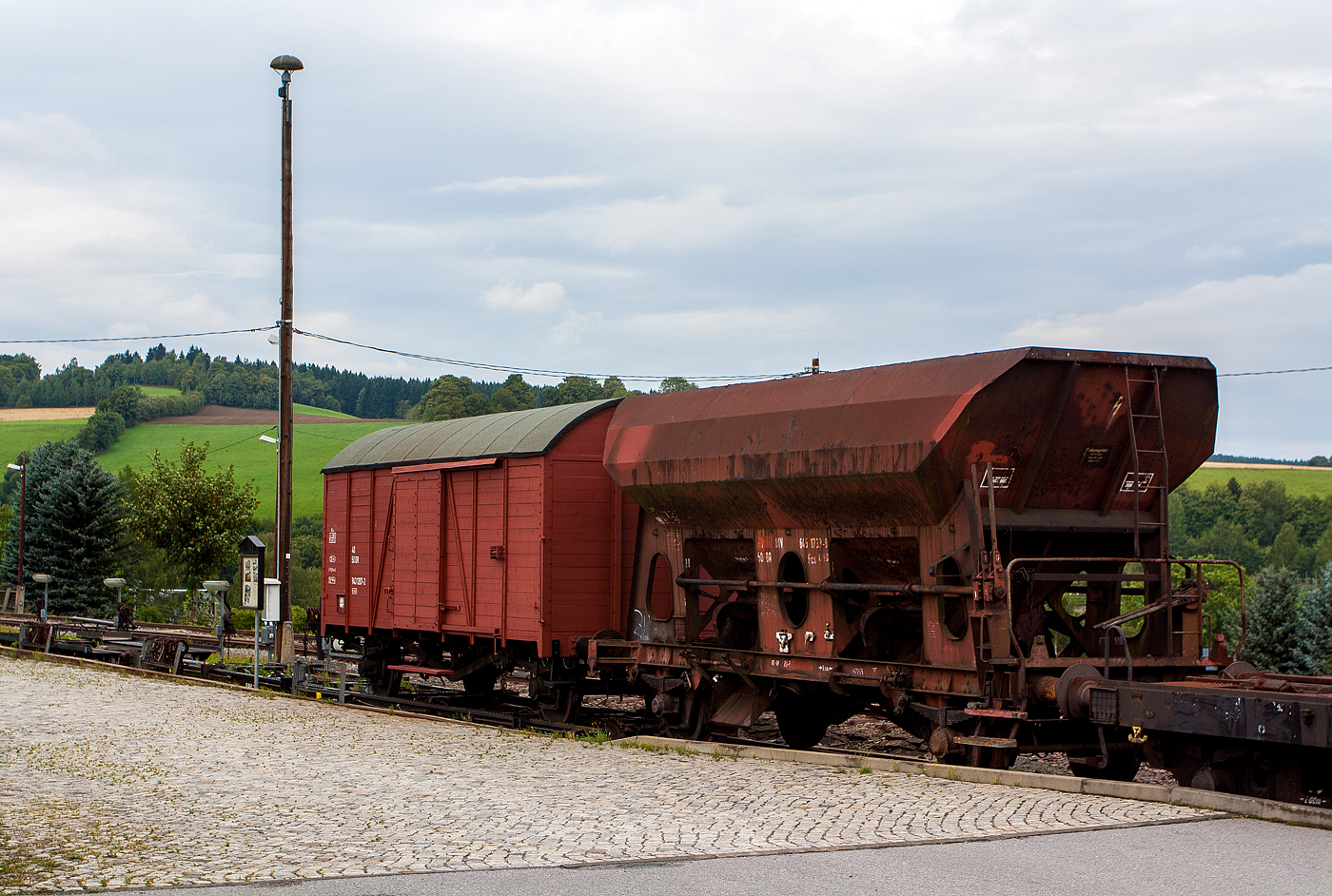 Der zweiachsige offener Güterwagen (Schotterwagen/Schüttgutwagen) 
21 RIV 50 DR 645 1 739-8 der Gattung Fcs 6451 und der zweiachsige gedeckte Güterwagen DR 40 50 943 1207-2 der DR Bauart 1139, beide jeweils aufgebockt auf Rollwagen in der Rollwagengrube beim Bahnhof Cranzahl, hier am 26 August 2013. 

1906 wurde auf der Fichtelbergbahn der Rollbock bzw. Rollwagenverkehr eröffnet. Dieser Güterverkehr (normalspurige Güterwagen aufgebockt schmalspurigen Rollwagen) bestand bis 1992. 

Auf den sogenannten schmalspurigen Rollwagen wurden normalspurige zweiachsige Güterwagen aufgebockt und mit diese transportiert. Bis zu 7 leere Güterwagen konnten dadurch bis Hammerunterwiesenthaln gefahren werden. Hauptsächlich wurden Kohle, Schotter und Holz von bzw. nach Oberwiesenthal befördert. Aber auch vierachsige normalspurige
Rungenwagen wurden auf zwei Rollwagen befördert. Diese dienten zur Abfuhr von Langholz (Bahnhof Vierenstraße).

Das Aufbocken und Abbocken der Güterwagen gehörte zu den schwersten Arbeiten bei der ehemaligen Deutschen Reichsbahn (DR). Besonders in der Wlsmut-Zeit und 1963, zum Aufbau des neuen Fichtelberg-Hauses, wurden ca.50 Güterwagen täglich auf- und abgebockt.

Der Schotterwagn:
Um Schütgut effektive und sicher befördern zu können, wurde in großen Stückzahlen Schotterwagen angefertigt. Man versuchte nach und nach das eine und andere zu standardisieren. So entstand o.a. die  Fcs 6451 . Dieser Typ wurde Mitte der 50-er Jahren in großen Stückzahlen gebaut von o.a. die Deutsche Industrie-Werke AG in Berlin-Spandau. 

In ähnlicher Form sind durch die Jahre, tausende Fcs Schotterwagen durch ganz Europa in dienstgestellt worden. Sie waren bei fast alle Eisenbahnen in Europa unterwegs. Auch in die Heutige Zeit gibt es noch viele Fcs Schotterwagen. Auch bei den Schmalspurbahnen waren und sind die Fcs Wagen an zu treffen. Auch bei die Harzer Schmalspurbahen waren die Fcs Schotterwagen oft zu gast, sowohl auf Rollwagen, als auch auf den modernen Vevey Rollböcken.
