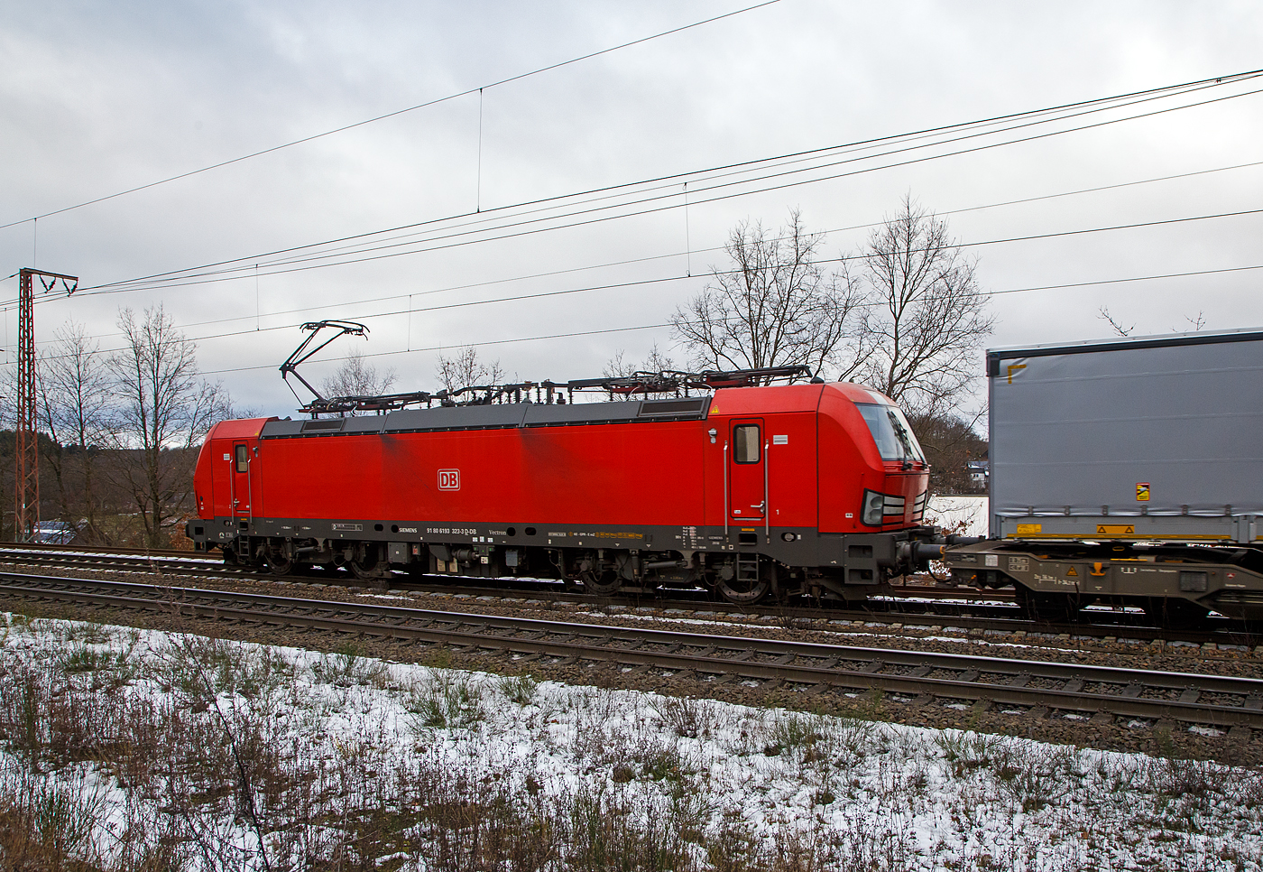 Die 193 323-3 (91 80 6193 323-3 D-DB) der DB Cargo AG fhrt am 27.01.2023 mit einem „HUPAC“ KLV-Zug durch Rudersdorf (Kr. Siegen) in Richtung Siegen. Hier befhrt der Zug die Dillstrecke (KBS 445) von dieser geht es bei Siegen-Ost auf die Siegstrecke (KBS 460) in Richtung Kln. Weil die Ruhr-Sieg-Strecke (KBS 440) nicht das KV-Profil P/C 400 aufweist, sind solche Zge dort nur bis Kreuztal zum Sdwestfalen Container-Terminal mglich.

Die Siemens Vectron MS (200 km/h - 6.4 MW) wurden 2018 von Siemens unter der Fabriknummer 22448 und gebaut, sie hat die Zulassungen fr Deutschland, sterreich, Schweiz, Italien und die Niederlande (D/A/CH/I/NL).