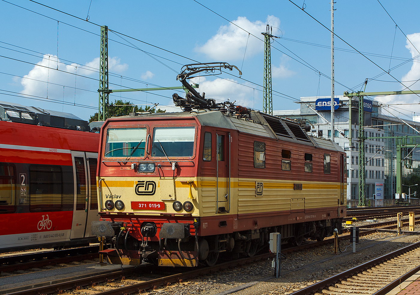 Die ČD 371 015-9  Václav  (Wenzel), ex ČD 372 015-8, ČSD 372 015-8 steht am 27.08.2013 beim Hbf Dresden. 

Die Lok (Škoda 76Em) wurde 1991 Škoda in Plzeň (Pilsen) unter der Fabriknummer 8782 für tschechoslowakischen Staatsbahn ČSD als 372 015-8 gebaut, der Wechselstromteil ist von LEW Hennigsdorf. Diese elektrische Zweisystemlokomotiven entstanden durch ein Gemeinschaftsprojekt der Tschechoslowakischen Staatsbahn ČSD und einstigen Deutschen Reichsbahn (DR), die deutschen Lok sind als Baureihen 180 (ex DR 230) eingereiht. In Deutschland tragen die Loks der BR 180 den  Spitznamen  Knödelpresse, oder wegen dem geringeren Wirkungsgrads auch den Spitznamen  Elbtalheizung . Auch das tschechische Pendant blieb nicht ohne Namen. Die Reihe 372 nennt man im Nachbarland  Bastard , diese 160 km/h schnellere Reihe 371  Turbobastard .

Bei dieser Lok erfolgte später, wie bei sechs Weiteren der Umbau von 120 km/h auf 160 km/h Höchstgeschwindigkeit und die Umzeichnung in ČD 371 015-9 (NVR-Nummer: CZ-ČD 91 54 7 371 015-9). Die Lokomotive 371.015 geriet am 29. Mai 2022 unweit des Bahnhofs Krippen in Brand und wurde beschädig.

Anfang der 1990er Jahre wurden die Lokomotiven der Baureihen 230 (DR) und 372 (ČSD) in Betrieb genommen. Mit ihnen begann der grenzüberschreitende elektrische Verkehr zwischen Děčín und Bad Schandau. Mit dem Ausbau der Strecke Dresden–Berlin für 160 km/h war die Baureihe 372 mit ihrer Höchstgeschwindigkeit von 120 km/h im hochwertigen Reisezugverkehr nicht mehr dort einsetzbar. Außerdem war auch der Ausbau der Bahnstrecke Praha–Děčín für 160 km/h geplant. Die Drehgestelle der Lokomotive waren lauftechnisch bis 200 km/h zugelassen, die Bremsausrüstung sowie die Getriebeübersetzung zwischen Fahrmotor und Treibradsatz waren jedoch nur für die zugelassene Geschwindigkeit 120 km/h ausgelegt.

Die Lokomotiven wurden zwischen 1996 und 2000 bei Škoda unter der Werksbezeichnung 76Em modernisiert. Insgesamt sechs Maschinen wurden zur Baureihe 371 umgebaut (Nummern 001, 002, 003, 004, 005 und 015), wobei die ursprünglichen Ordnungsnummern beibehalten wurden. Die Tests mit den umgebauten Lokomotiven verliefen aber nicht so, wie man sich es vorgestellt hatte: Bei den tschechischen Lokomotiven brachen wiederholt die Schleifstücke der Stromabnehmer, wodurch jedes Mal großer Schaden entstand, da der gebrochene Stromabnehmer die Fahrleitung herunterriss. Daraufhin wurden die Stromabnehmer der Lokomotiven auf einzeln gefederte Schleifstücke umgebaut.

TECHNISCHE DATEN:
Gebaute Loks: 15 der  ČSD BR 372 / 20 der DR BR 230 (DB 180)
Umgebaute Loks: 7 (zu BR 371)
Hestellertyp: Škoda 76E (nach Umbau 76Em) (für DR Škoda 80E)
Spurweite:  1.435 mm
Achsfolge:  Bo'Bo'
Länge über Puffer:  16.800 mm
Drehzapfen-Abstand: 8.360 mm
Achsabstand im Drehgestell: 3.200 mm
Eigengewicht:  84 t
Achslast:  21 t
Höchstgeschwindigkeit: 160 km/h
Anfahrzugkraft: 205 kN
Dauerzugkraft: 141,6 kN
Stundenleistung: 3.260 kW
Dauerleistung:  3.080 kW
Anzahl der Fahrmotoren: 4
Antrieb: Kardanantrieb in Hohlwelle
kleinster befahrbarer  Radius: 120 m  

Einsatz:
Die Lokomotiven verkehrten vor den EuroCity-Zügen zwischen Praha hlavní nádraží und Dresden Hbf. Mit dem Zugpaar EC 258/259 kamen die Lokomotiven auch bis Leipzig Hbf. Bereits zum Dezember 2015 sollten Lokomotiven der ČD-Baureihe 380 diese Züge zwischen Prag, Berlin und Hamburg durchgehend bespannen. Das für die deutschen Schienenwege zuständige Eisenbahninfrastrukturunternehmen DB Netz verweigerte allerdings zunächst eine uneingeschränkte Zulassung. Für die durchgehende Traktion der Eurocityzüge von Prag nach Hamburg werden deshalb seit Dezember 2017 Dreisystemlokomotiven des Typs Siemens Vectron eingesetzt. Die Lokomotiven der Reihe 371 bespannen seitdem nationale Züge auf der Strecke Prag – Staré Město u Uherského Hradiště. In der Sommerzeit und im Advent wird der Regionalzug der Linie RE20 zwischen Ústí nad Labem und Dresden weiterhin mit einer Lokomotive der Reihe 371 bespannt.
