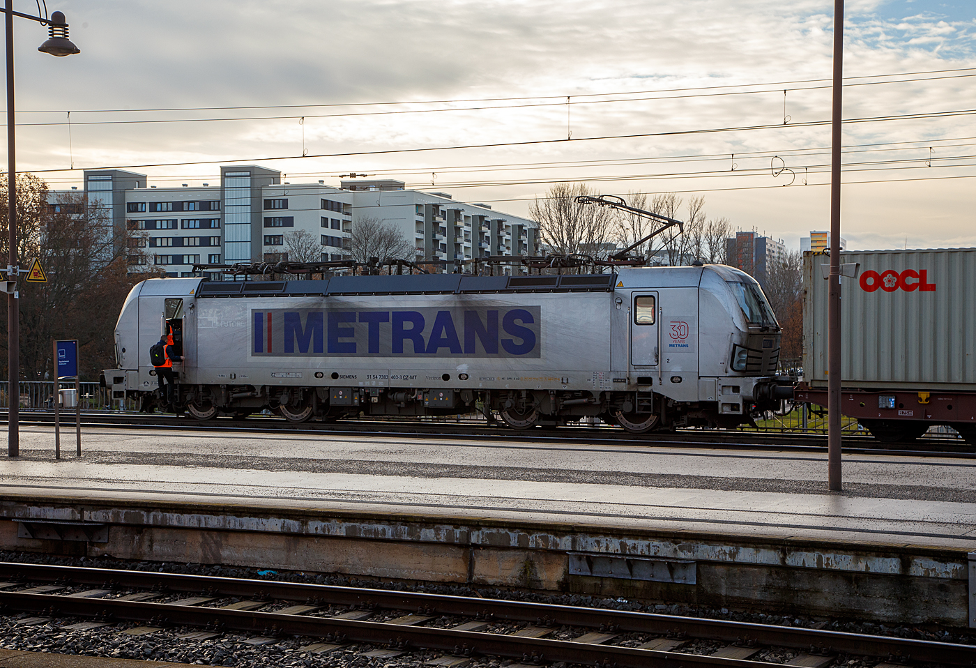 Die 383 403-3 (91 54 7383 403-3 CZ-MT), eine Siemens Vectron MS der METRANS Rail s.r.o. (Prag / Praha), am 08.12.2022 mit einem Containerzug im Hauptbahnhof Dresden, hier wechseln gerade die Lokführer/-in bevor es in Richtung Tschechien weiter geht. Die METRANS gibt es schon über 30 Jahren, sie ist ein 100 %-iges Tochterunternehmen der Hamburger Hafen und Logistik AG (HHLA).

Die Siemens Vectron MS (Vectron X4 A01) wurden 2019 von Siemens Mobilitiy in München-Allach unter der Fabriknummer 22693 gebaut und an die METRANS geliefert. Die Vectron MS in der Version A01hat die Zulassungen und Zugbeeinflussungssysteme für Tschechien, Deutschland, Österreich, Slowakei, Ungarn und Polen (CZ, D, A, SK, H, PL). Die neuen Lokomotiven für Metrans erreichen eine Höchstleistung von 6,4 MW und eine Spitzengeschwindigkeit von 160 km/h. 

Zukünftige Aufrüstungen für den Einsatz in Bulgarien, Kroatien, den Niederlanden, Rumänien, Serbien und Slowenien sind möglich.