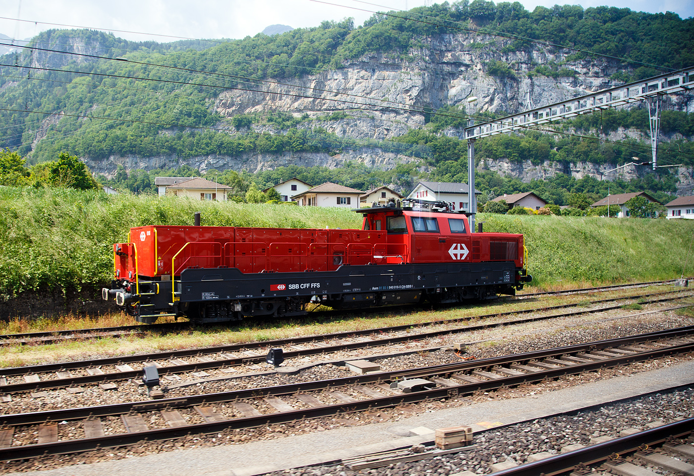 Die Aem 940 018-5 (Aem 91 85 4 940 018-5 CH-SBBI), eine Alstom Prima H4 der SBB Infrastruktur, ist am 28.05.2023 bei Saint-Maurice abgestellt (aus dem Zug heraus aufgenommen). 