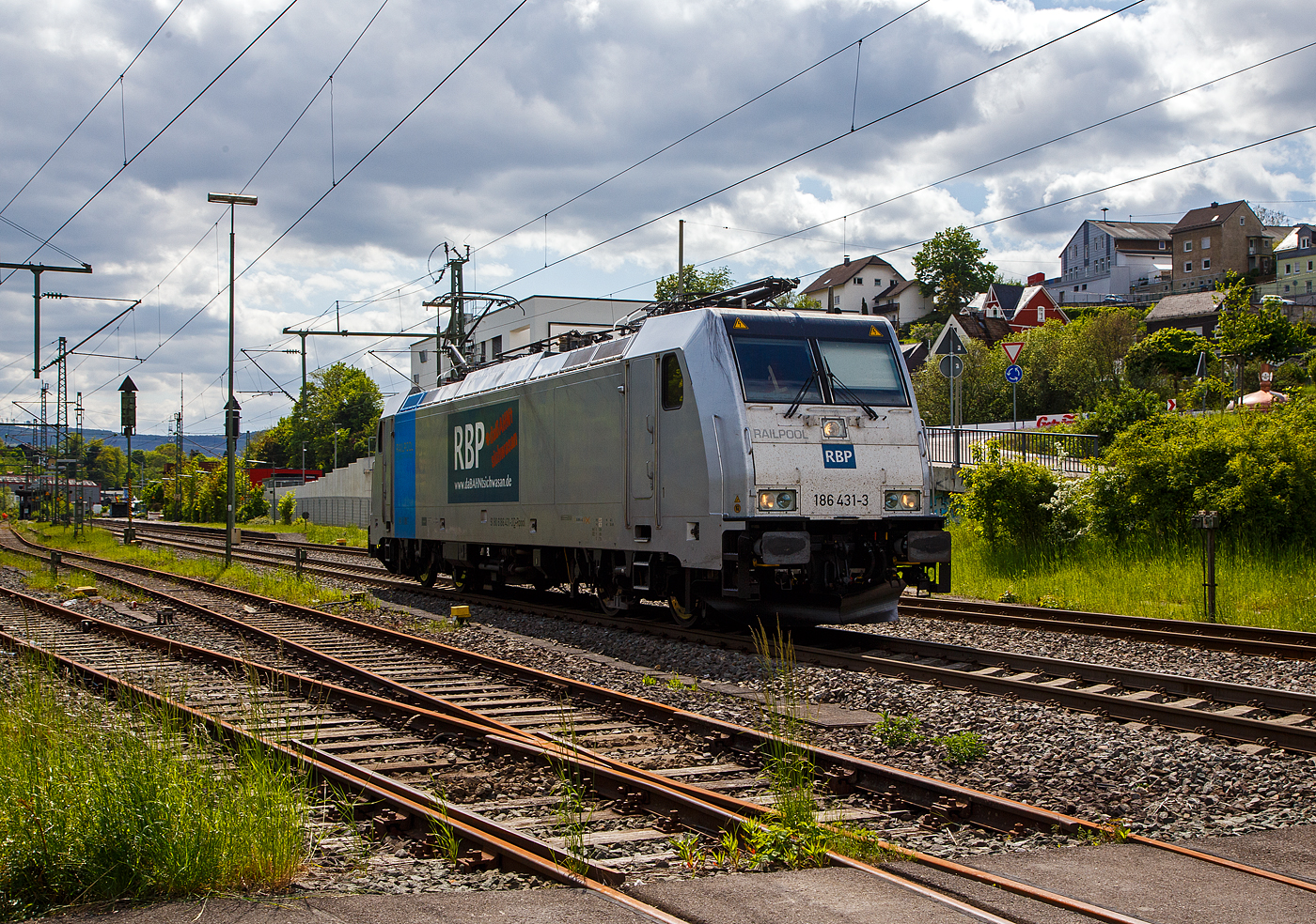Die an die RBP - Rheinische Bahnpersonal- und Verkehrsgesellschaft mbH (Siegburg) vermietete Railpool 186 431-3  (91 80 6186 431-3 D-Rpool) fährt am 16.05.2023 als Lz (Lokzug) bzw. auf Tfzf (Triebfahrzeugfahrt) durch Niederschelden in Richtung Siegen. Hinweis ich stehe an der Schranke vom Bü 343 – km 112,183 der Siegstrecke.

Die Bombardier TRAXX F140 MS(2E) wurde 2015 von Bombardier in Kassel unter der Fabriknummer 35185 gebaut und an die Railpool GmbH (München) ausgeliefert. Die Multisystemlokomotive hat die Zulassungen bzw. besitzt die Länderpakete für Deutschland, Österreich, und Tschechien (D/A/CZ). Ursprünglich war sie für Polen, Slowakei, Ungarn und die Niederland (PL/SK/HU/NL) zugelassen, aber aktuell sind diese Länderkürzel an die Lok durchgestrichen.


Der derzeitige Mieter die RBP - Rheinische Bahnpersonal- und Verkehrsgesellschaft mbH in Siegburg, ist eine junge und moderne Eisenbahnverkehrsgesellschaft, speziell für Bahn- und Verkehrsbetriebe. 
