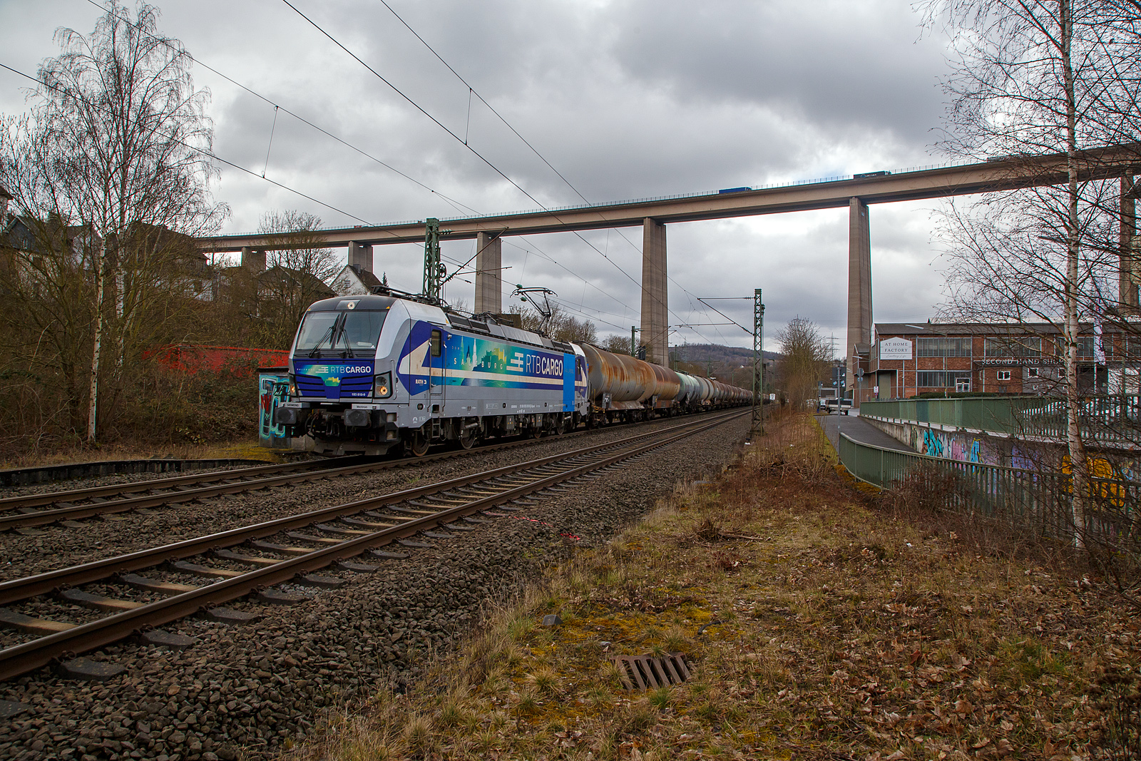 Die an die RTB Cargo GmbH vermietete SIEMENS Vectron AC – 193 810-9 „Salzburg“ (91 80 6193 810-9 D-Rpool) der Railpool GmbH (München), fährt am 22.03.2021 mit einem Kesselwagenzug durch Siegen-Eiserfeld in Richtung Siegen. Im Hintergrund die 105 m hohe Siegtalbrücke der A45 (Sauerlandlinie).

Die Siemens Vectron AC wurde 2014 von Siemens Mobility GmbH in München-Allach unter der Fabriknummer 21898 gebaut und an die Railpool GmbH in München geliefert. Diese Vectron Lokomotive ist als AC – Lokomotive (Wechselstrom-Variante) mit 6.400 kW konzipiert und zugelassen für Deutschland, Österreich, Ungarn und Rumänien, sie hat eine Höchstgeschwindigkeit von 200 km/h.