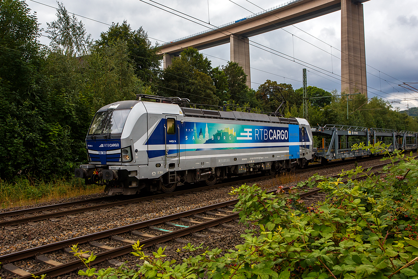 Die an die RTB Cargo GmbH vermietete SIEMENS Vectron AC – 193 810-9 „Salzburg“ (91 80 6193 810-9 D-Rpool) der Railpool GmbH (M�nchen), f�hrt am 22 Juli 2026 mit einem leeren offenen Doppelstock-Autotransportzug der ARS Altmann AG (mit Wagen der Gattung Laaers 560.1), durch Siegen-Eiserfeld in Richtung Siegen. Im Hintergrund die 105 m hohe Siegtalbr�cke der A45 (Sauerlandlinie).

Die Siemens Vectron AC wurde 2014 von Siemens Mobility GmbH in M�nchen-Allach unter der Fabriknummer 21898 gebaut und an die Railpool GmbH in M�nchen geliefert. Diese Vectron Lokomotive ist als AC – Lokomotive (Wechselstrom-Variante B02) mit 6.400 kW konzipiert und zugelassen f�r Deutschland, �sterreich, Ungarn und Rum�nien, sie hat eine H�chstgeschwindigkeit von 200 km/h.