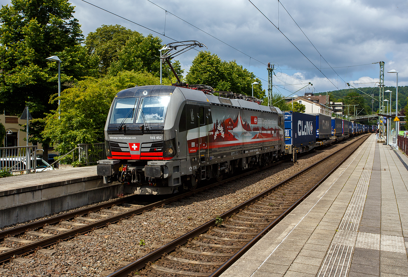 Die an die SBB Cargo International AG vermietete mit „XLoad“ ausgestattete 193 452  Helvetia  (91 80 6193 452-0 D-SIEAG) der SüdLeasing GmbH, Stuttgart (eingestellt in Deutschland durch Siemens) fährt am 17 Juli 2025 mit einem KLV-Zug, durch Kirchen (Sieg) in Richtung Köln.

Die Multisystemlokomotive Siemens Vectron MS wurde 2024 von Siemens Mobilitiy in München-Allach unter der Fabriknummer 23637 gebaut. Sie wurde in der Variante A40-1a ausgeführt und hat so die Zulassung für Deutschland, Österreich, die Schweiz, Italien, die Niederlande und Belgien (D / A / CH / I / NL / B). Sie verfügt über eine Leistung von 6,4 MW (160 km/h) und ist neben den nationalen Zugsicherungssystemen mit dem Europäischen Zugsicherungssystem (ETCS BL3) ausgestattet. Zudem ist sie mit der neuen Ausrüstungspaket XLoad ausgestattet. 

Das neue XLoad Ausrüstungspaket für Vectron:
XLoad ist ein Ausrüstungspaket für Vectron, welches künftig mitbestellt, aber auch bei bereits ausgelieferten Vectron Loks nachgerüstet werden kann. Das Feature verbessert die Reibwertausnutzung und ermöglicht dadurch höhere Anhängelasten. Zudem reduzieren die Fahreigenschaften, die das Feature bewirken, den Verschleiß von Rad und Schiene.

Aktuell sind die Schweizer Vectron-Lokomotiven (SBB Cargo und BLS Cargo) in der Regel in Doppeltraktion unterwegs. Die Steigungen und Rampen der Schweizer Berge sind vor allem bei schlechten Witterungsbedingungen nicht ohne. Eine Lokomotive muss auch bei geringerem Schlupf genügend Traktion auf die Schienen bringen, um alle Güter sicher und zuverlässig ans Ziel zu bringen. Ein effizienter Weg aus dieser «Misere» ist die für Vectron entwickelte Zusatz-Funktion «XLoad». Den erfolgreichen Beweis trat eine SIEMENS Testlokomotive im Frühjahr 2022 bei der SBB Cargo International und bei der BLS Cargo eindrücklich an. 

Für SBB Cargo International bewies die Test-Lokomotive am Bözberg und für BLS Cargo an der Nordrampe des Lötschbergs ihre enorme Zugkraft. 
Vectron meisterte im Frühjahr 2022 die lange 12‰-Steigung des Bözbergs mit einer Anhängerlast von 2.000 Tonnen bravourös. Bei den nächtlichen Testfahrten zeigte sich eindrücklich die enorme Zugkraft der Lokomotive. 

Am Lötschberg wurden bei der BLS Cargo steigungsmäßig noch ein paar Promille draufgepackt. Mit 1.020 Tonnen im Gepäck bewältigte die Vectron-Lokomotive mit XLoad-Feature die 27‰-Steigung der Nordrampe ebenfalls meisterlich. Und auch diverse Anfahrtsversuche absolvierte der mit dem XLoad-Feature aufgerüstete Vectron problemlos. So bestellte die SüdLeasing GmbH (Stuttgart) im Auftrag der SBB Cargo International jüngst 20 Vectron Lokomotiven mit XLoad bei SIEMENS.
