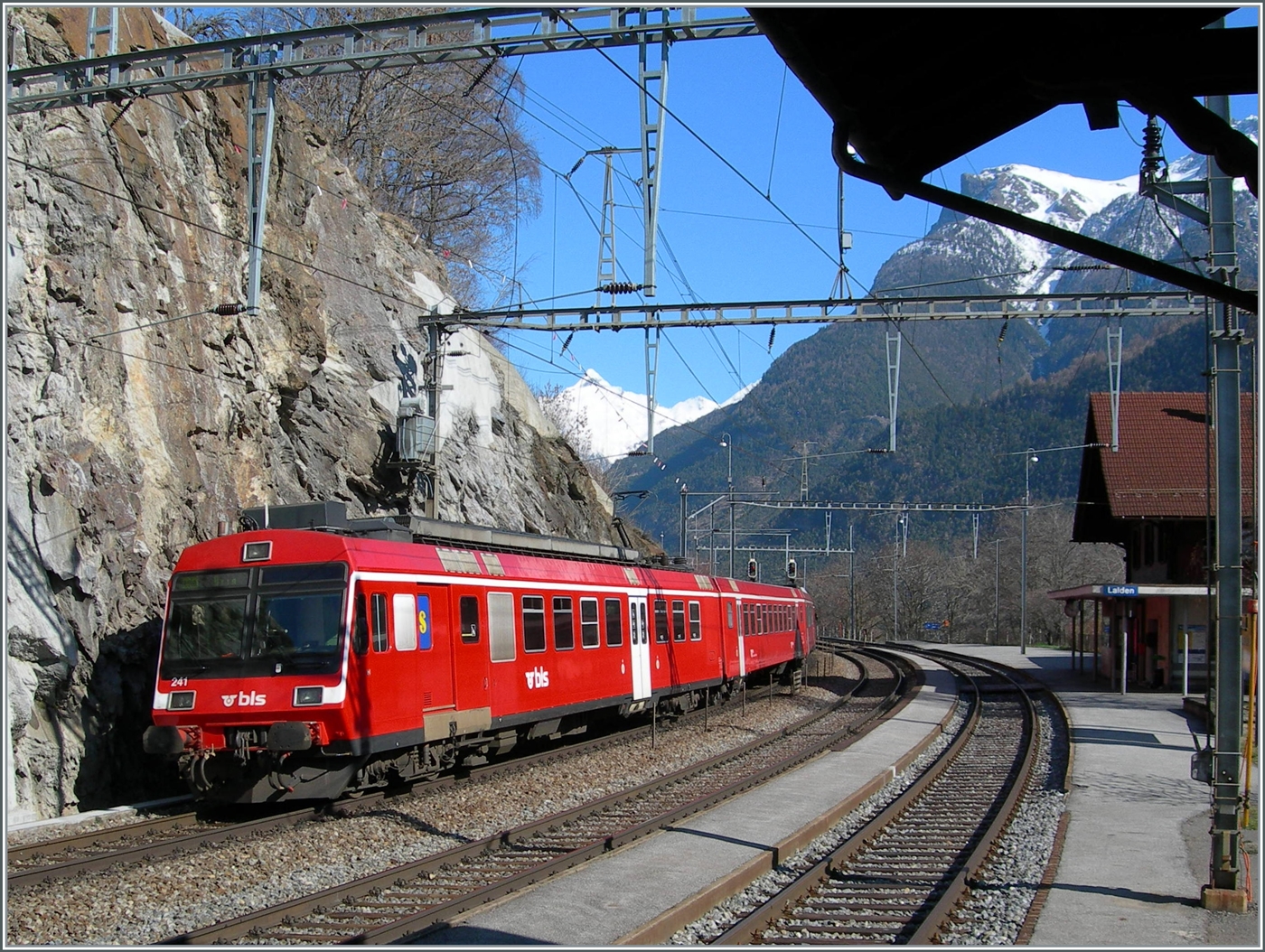 Die von bei der Fusion von der RM übernommen RBDe 566 Pendelzüge fuhren einige Zeit im RM Rot als BLS Regionalzüge. Mit dem dem schiebenden RBDe 566 241 verlässt der Regionalzug von Goppenstein nach Brig den Bahnhof Lalden.

16. März 2007
