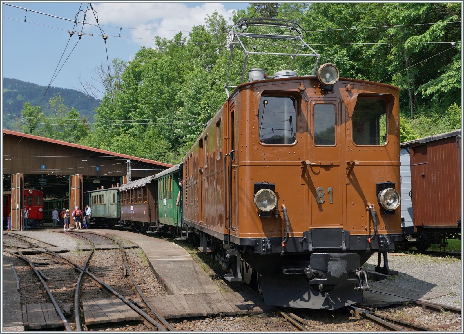 Die Bernina Bahn RhB Ge 4/4 81 der Blonay-Chamby Bahn ranigert in Chaulin einen langen Reisezug. Rechts im Hintergrund ist der RhB ABe 4/4 35 zu erkennen, der nun frisch gestrichen hoffentlich bald wieder im Einsatz zu erleben ist. 

28. Mai 2023