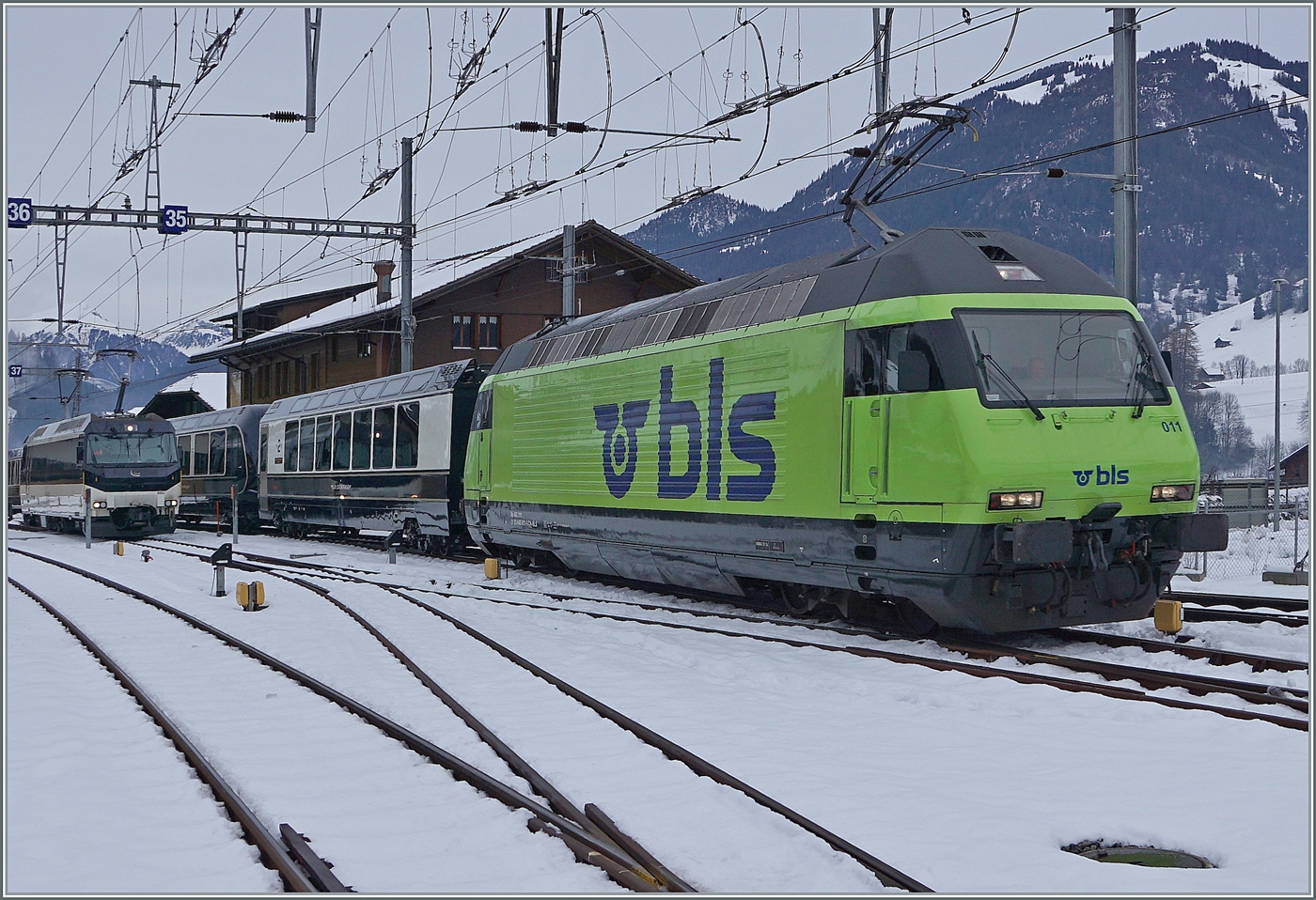 Die BLS Re 465 011 erreicht mit ihrem GoldenPass Express GPX 4065 von Interlaken Ost nach Montreux den Spurwechselbahnhof Zweisimmen. Im Hintergrund wartet die MOB Ge 4/4 8002 welche die Traktion des Zugs auf der schmalspurgien MOB übernehmen wird. 
Gleich hinter der Lok der sogenante  Interface -Wagen, nur auf dem Normalspurabschnitt mitgeführt wird und mit der Lok dann durch die  ausgeschaltete  Umspuranglage rollen wird.

15. Dezember 2022