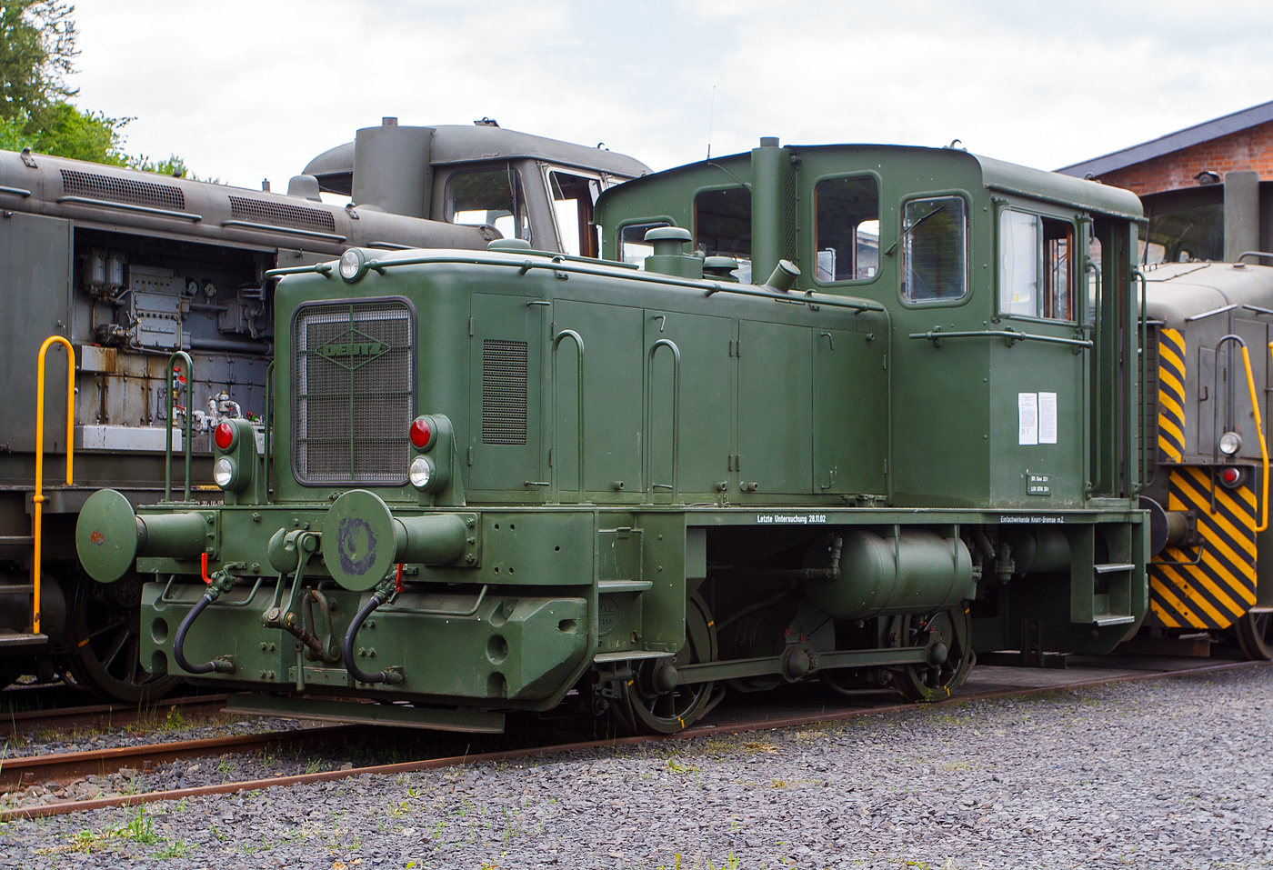 Die Deutz 57513 - eine DEUTZ  KS 230 B Diesellokomotive ehemals der Bundeswehr, am 18 Mai 2014 ausgestellt beim Erlebnisbahnhof Westerwald der Westerwälder Eisenbahnfreunde 44 508 e. V. hier war Museumstag. Die Lok ist Eigentum vom Militärhistorisches Museum Dresden und eine Leihgabe an die Eisenbahnfreunde. In der Lokstatuon Westerburg findet man eine einzigartige Spezialsammlung von Schienenfahrzeugen der Bundeswehr.

Die Lok wurde 1962 bei Deutz unter der Fabriknummer 57513 gebaut und an die BW (Fliegerhorstgruppe Erding) ausgeliefert, 2007 wurde sie außer Dienst gestellt.

Die Lokomotive KS 230 B ist die Weiterentwicklung der A12L 614 R und kam Anfang der Sechziger Jahre auf den Markt. Die erste Maschine wurde am 28. Februar 1962 ausgeliefert.
Die DEUTZ-Diesellok KS 230 B (A12L 714A) ist eine zweiachsige Rangiermaschine mit hydraulischer Kraftübertragung und Stangenantrieb. Als Antriebsmotor wird der luftgekühlte DEUTZ-Vielstoffmotor A12L 714 A mit einer Leistung von 230 PS verwandt. Die Motorleistung wird über eine Gummi-Dämpfungskupplung und Gelenkwelle auf das VOITH-Getriebe L 33 yUb übertragen. Von hier aus wird die Antriebskraft über das angeflanschte Wendegetriebe auf die zwischen den Achsen liegende Blindwelle weitergeleitet, die über Kurbeln, Treib- und Kuppelstangen beide Radsätze antreibt. Die Lokomotive hat ein Dienstgewicht von etwa 28 Tonnen und erreicht bei einer Zugkraft von 7000 kg auf gerader horizontaler Strecke eine Maximalgeschwindigkeit von 30 km/h. Der Kraftstoffverbrauch beträgt bei 50 % Durchschnittsbelastung um die 22 Kilogramm Dieseltreibstoff pro Stunde.

Am 19. Dezember 1961 wurde zwischen dem Bundesamt für Wehrtechnik und Beschaffung und der KHD AG, Köln-Deutz, der Hauptvertrag über die Lieferung von 21 Lokomotiven geschlossen. Diese Fahrzeuge waren für den Einsatz in Liegenschaften der Luftwaffe und Marine bestimmt. Sie erhielten die Versorgungsartikel-Bezeichnung:  Lokomotive, Vielstoff, 1.435 mm Spurbreite, 200 PS  und wurden der Versorgungsnummer 2210-12-137-0042 zugeordnet.
Die Inbetriebsetzung der Maschinen bedeutete allerdings nicht für alle Fahrzeuge auch gleichzeitig den geplanten Einsatz. Viele bürokratische Hemmnisse, fehlende Infrastruktur und Betriebskostenrechnungen aus unterschiedlichster Betrachtungsweise führten dazu, dass Ende 1963 nur acht der Loks im planmäßigen Einsatz waren. Die übrigen dreizehn Loks standen unbenutzt an den einzelnen Standorten abgestellt. Mangelnde Erfahrung, nicht erfolgte Wartungen und mangelhafte Unterbringung der Fahrzeuge führten naturgemäß zu Störungen bei den nachfolgenden Inbetriebnahmen.

Der Ersatzteilservice, anstehende Reparaturen, sowie Frist- und Hauptuntersuchungen, wurden bis zur Einstellung der Lokomotivproduktion bei KHD Köln-Deutz, vom Lieferanten im Einzelauftragsverfahren vorgenommen.
Ab 1972 übernahm die Firma Henschel & Sohn, Kassel die Wartung und Instandsetzung von Deutz - Lokomotiven.
Das Bundesamt für Wehrtechnik und Beschaffung strebte allerdings zur Kostenreduzierung den Abschluss eines Instandhaltungs - Rahmenvertrages für alle Lokomotiven der Bundeswehr an. Es galt eine Werkstatt zu finden, die über das notwendige Know-How verfügte, um alle Arbeiten über die gesamte Palette der Bundeswehr - Lokomotiven fachgerecht auszuführen. In Moers wurde man fündig und so wurde wurde am 09. Juli 1975 ein Vertrag zwischen der Firma MaK Kiel, Reparaturwerk Moers und dem BwB Koblenz geschlossen, der den gesamten Bestand von damals 50 regelspurigen Lokomotiven umfasste.
Quelle: http://www.bundeswehrloks.de/

Technische Daten:
Typ:  KS 230 B
Spurweite: 1.435 mm (Normalspur)
Länge über Puffer:   7.310 mm
Achsanzahl:  zwei (B-dh)
Motor:  KHD luftgekühlter 12-Zylinder-V- Vielstoffmotor A12L 714 A
Hubraum: 19,0 l
Leistung: 170 kW (230 PS) bei 2000 U/min
Getriebe: Voith L 33 yUb
Antriebübertragung: s.o.
Dienstgewicht:  28 t
Höchstgeschwindigkeit: 32 km/h
Raddurchmesser  850 mm
Anfahrzugkraft  9000 kg / 90 kN
Bremse:  Knorr Druckluftbremse
