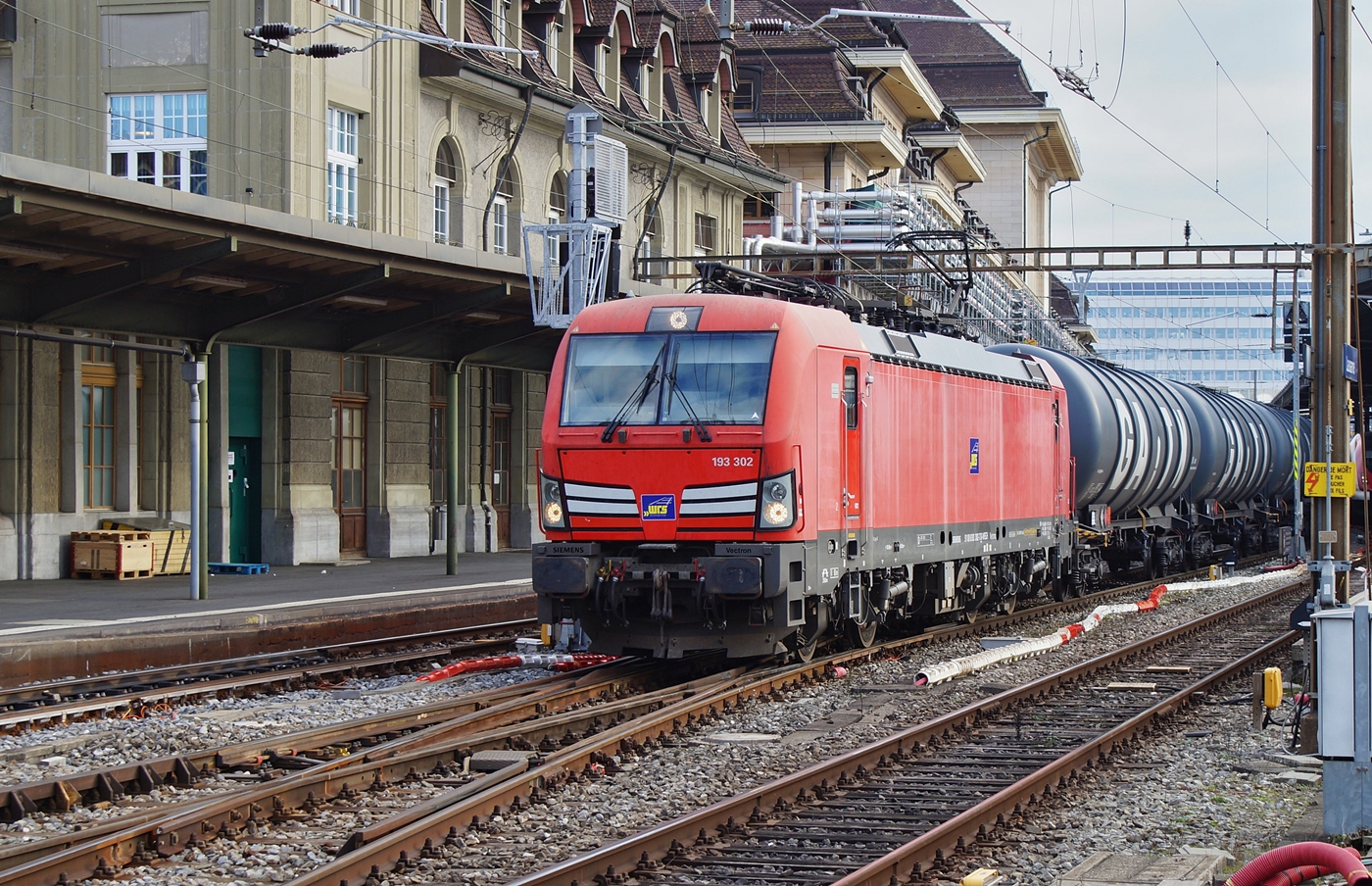 Die (ex DB) WRS 193 302 (91 80 6193 302-7 D-WRSCH) steht mit einem langen Kesselwagenzug in einige Zeit in Lausanne bevor ihre Fahrt weitergeht. Die Lok hat gemäss der Anschrift eine Zulassung in D, A, CH, I, NL und B. Gleich neben der Kennzeichnung der Länderzulassung stehen die Werte für die Zugsammelschiene angeschrieben: 3000 V , 1500 V, 1500 V 50 Hz und 1000 V 16,7 Hz. Interessant finde ich, dass der über ein Jahrhundert alte Wert 16 2/3 Hz nun mit 16,7 Hz angegeben wird. Leider stand die Lok mit ihrem Zug fotografisch gesehen sehr ungeschickt, was hauptsächlich auf die Länge der Zuges zurückzuführen ist. 

5. Januar 2026