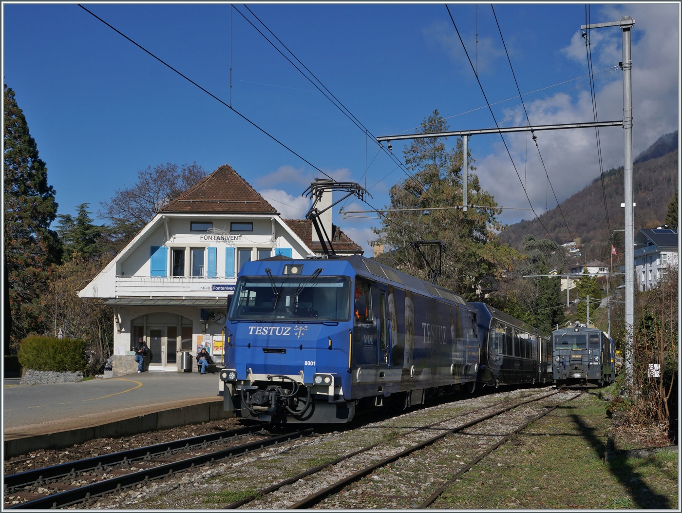 Die MOB Ge 4/4 8001 fährt mit ihrem GoldenPass Express GPX 4074 von Montreux nach Interlaken Ost durch den Bahnhof von Fontanivent. Im Hintergrund ist die GDe 4/4 6002 abgestellt.

13. Februar 2024