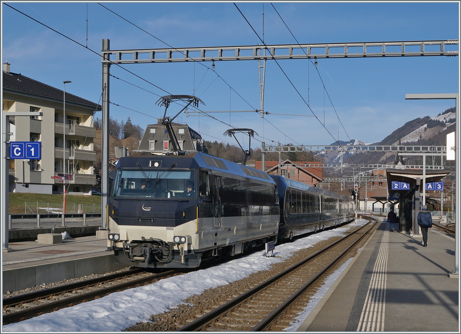 Die MOB Ge 4/4 8002 wartet mit ihrem GoldenPass Express (GPX) im TPF Bahnhof Montbovon auf den Gegenzug und die Weiterfahrt in Richtung Interlaken Ost. 

20. Jan. 2026